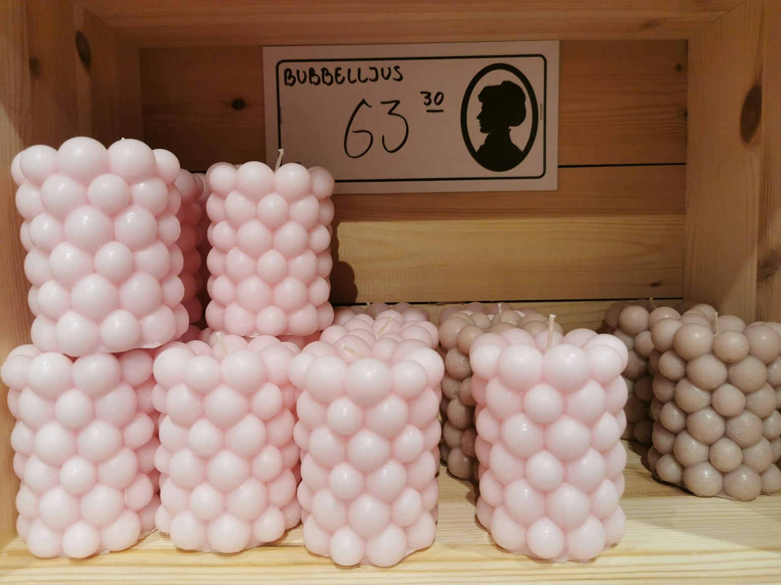 Pink candles with a round design arranged in a wooden box