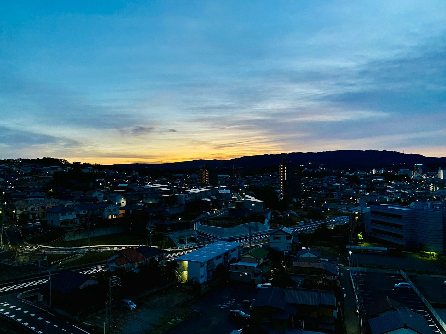 Vue de la ville au crépuscule avec des bâtiments et des maisons sous un ciel coloré