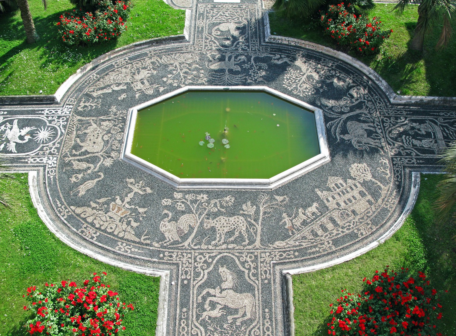 Diseño de jardín con un camino de piedra tallada que rodea un estanque verde