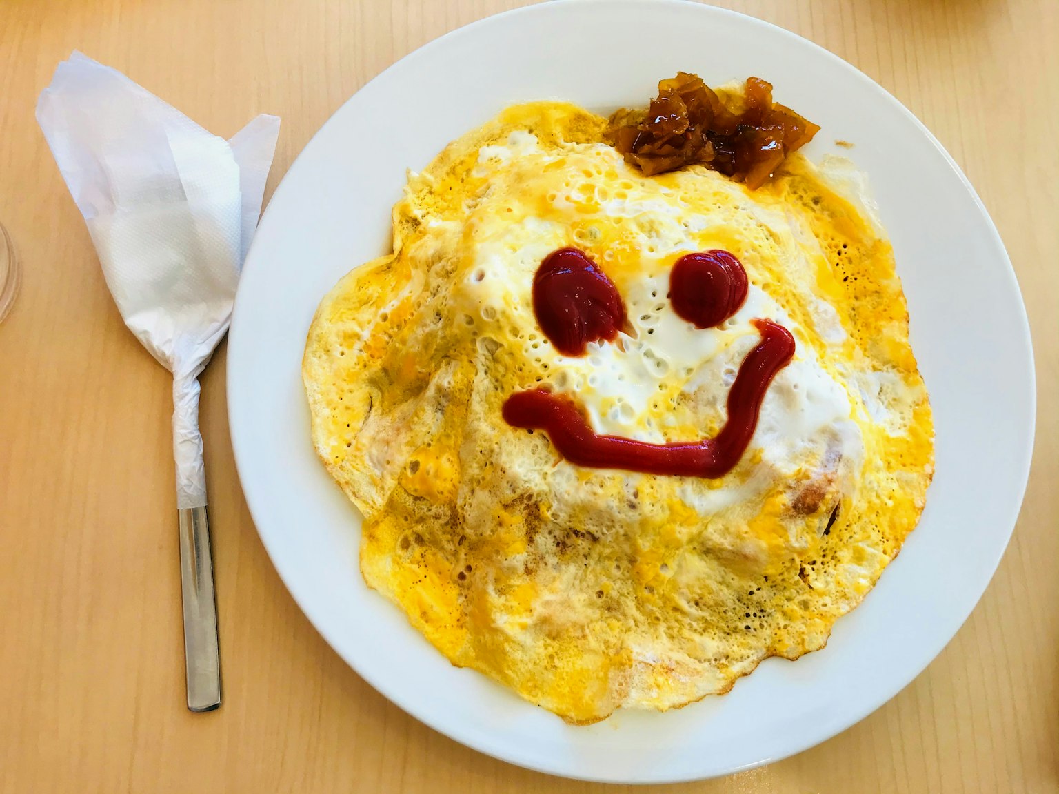 Arroz omelette con una cara sonriente hecha de ketchup encima