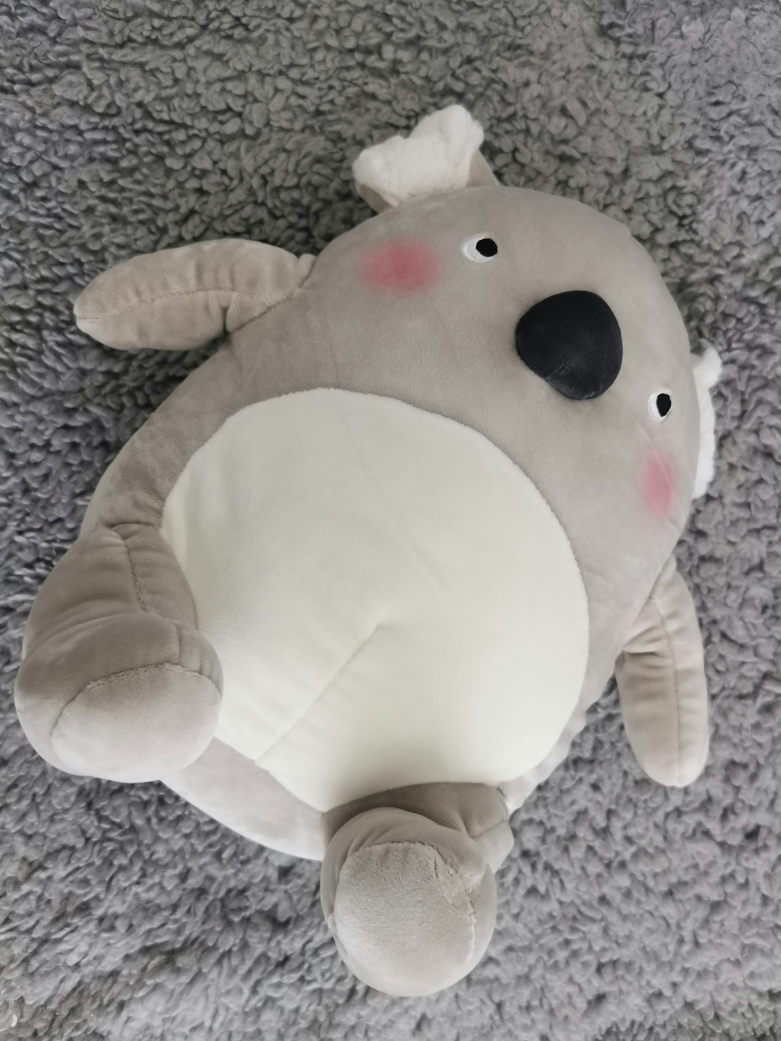 Juguete de peluche de koala lindo acostado sobre una superficie suave