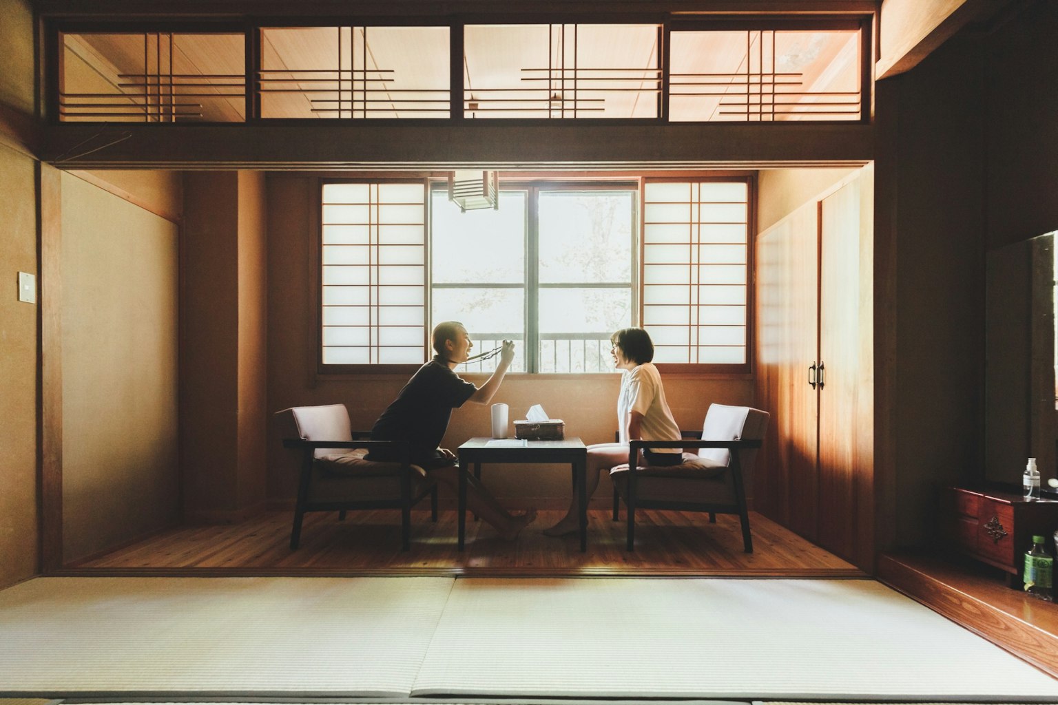 Two people sitting at a table in a traditional Japanese room
