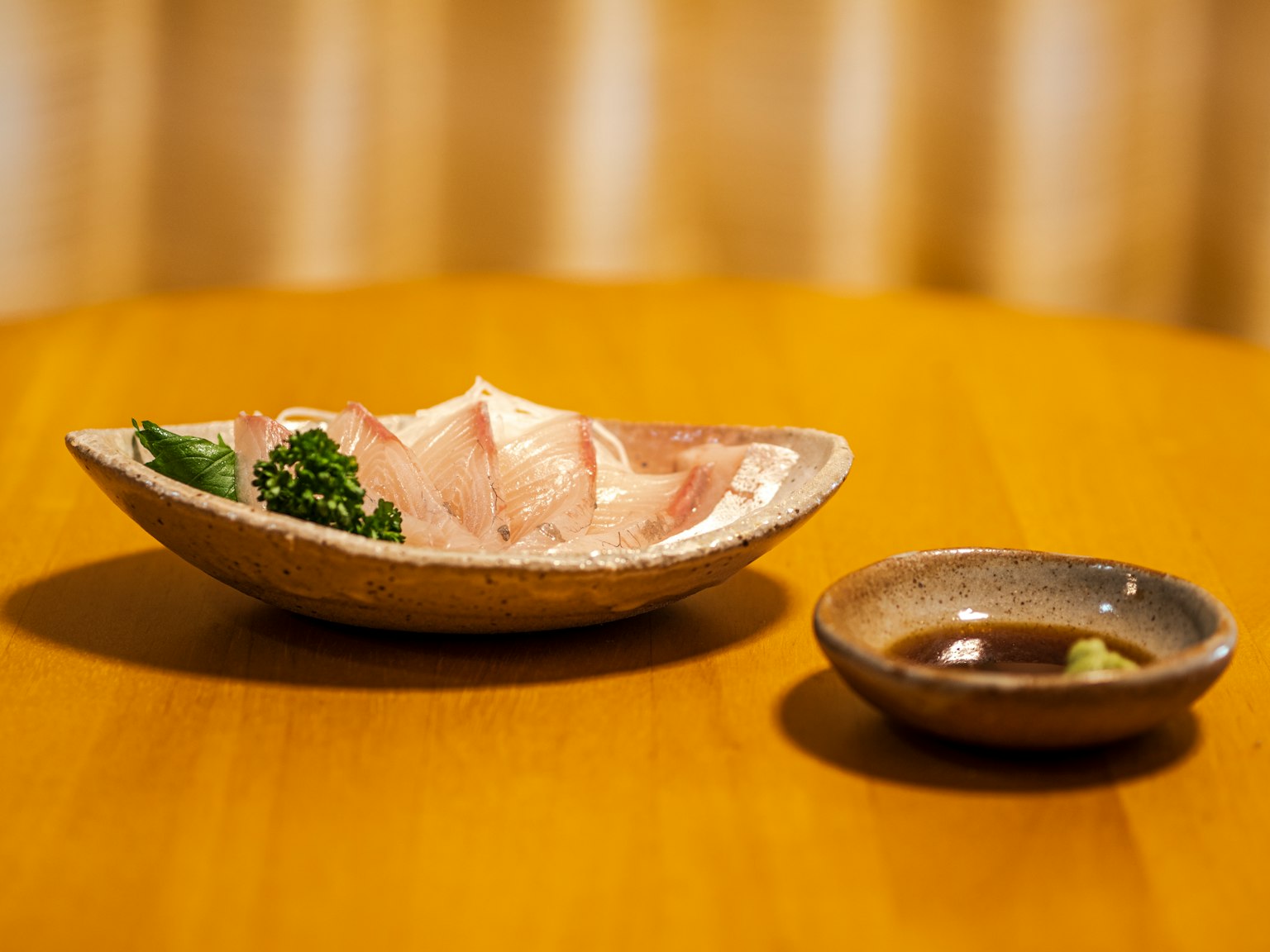 Sashimi auf einem schönen Keramik-Teller serviert mit Sojasauce und Wasabi daneben