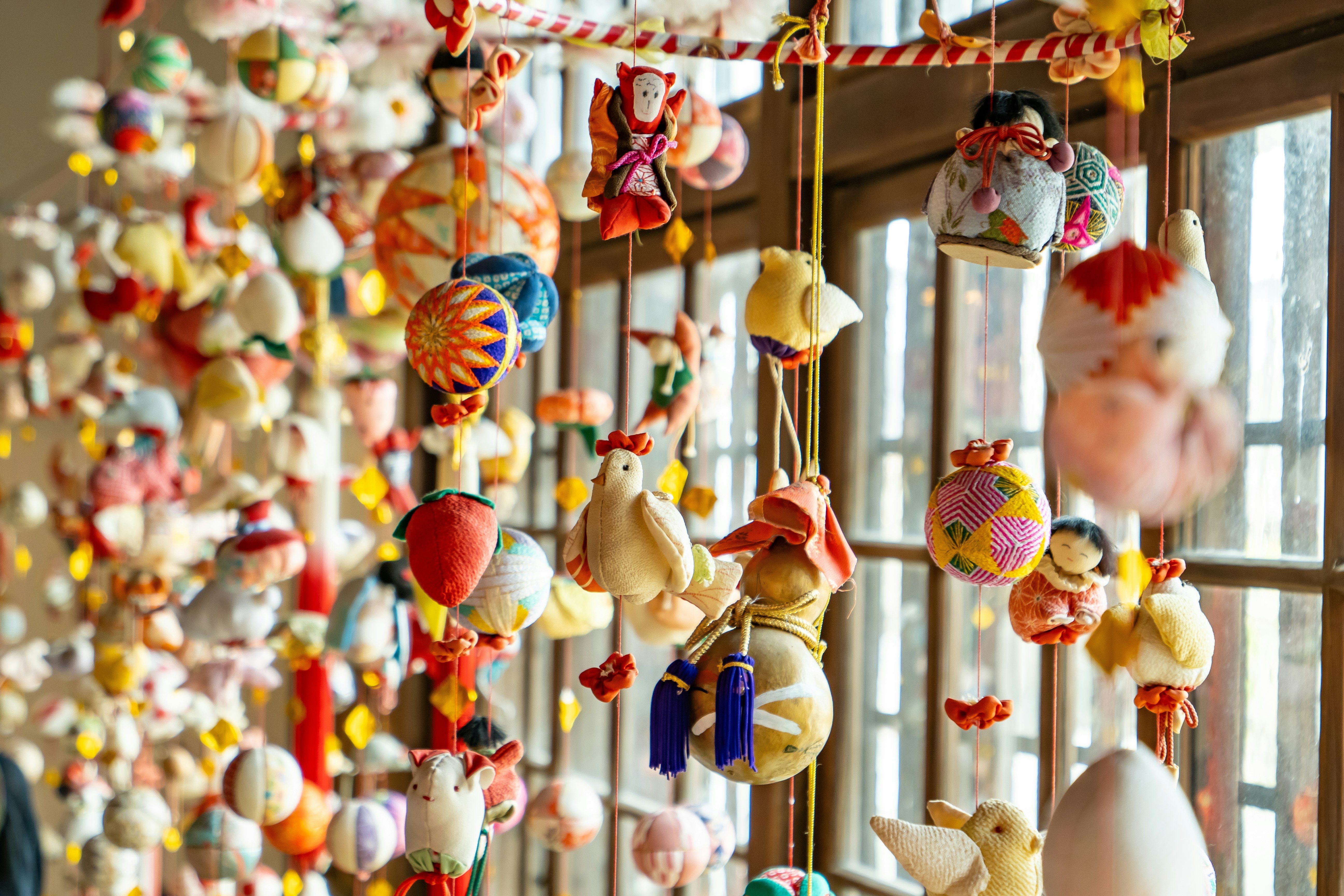 Buntes Weihnachts-Ornament-Mobile an einem Fenster
