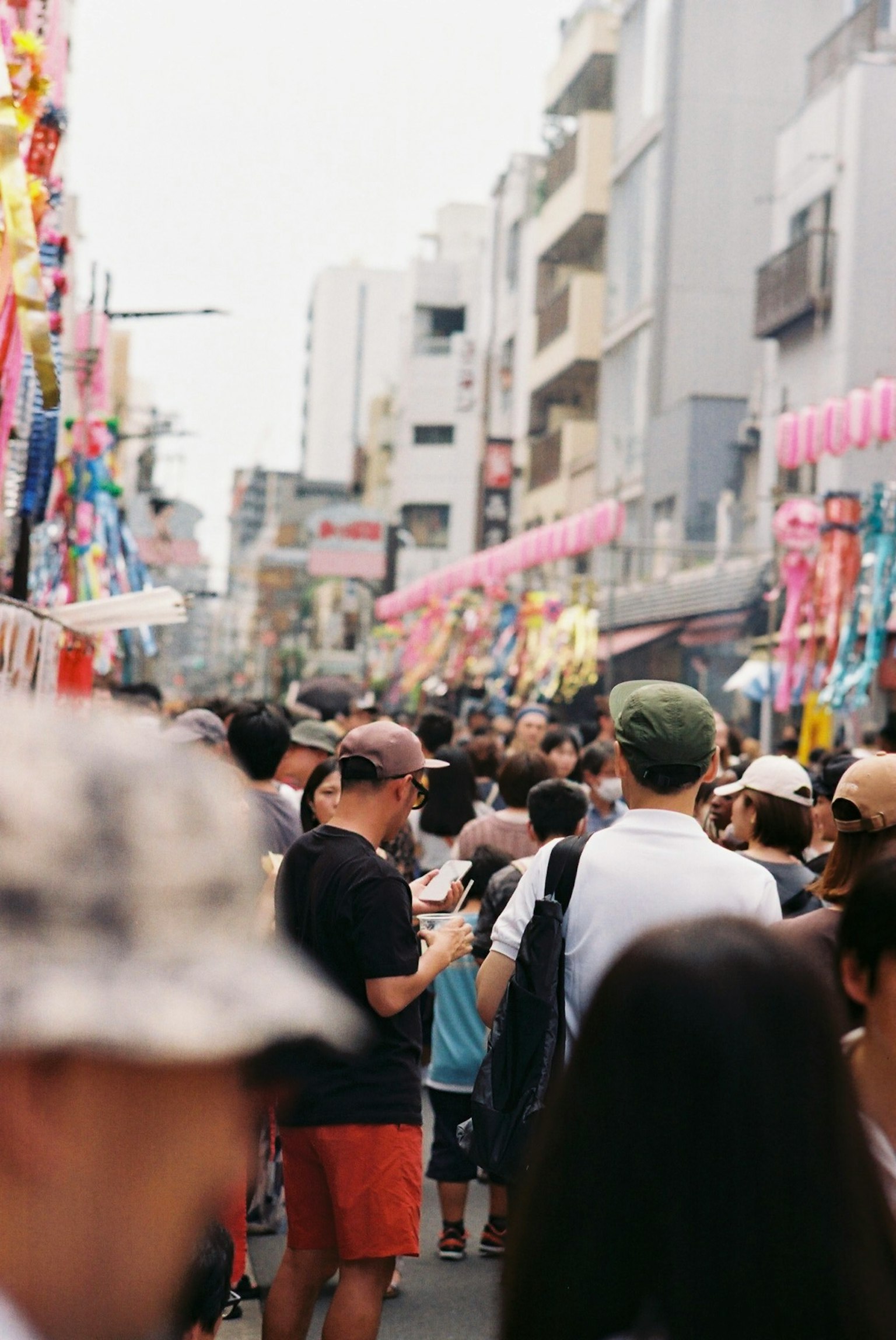 Crowd of people on a busy street decorated with colorful banners