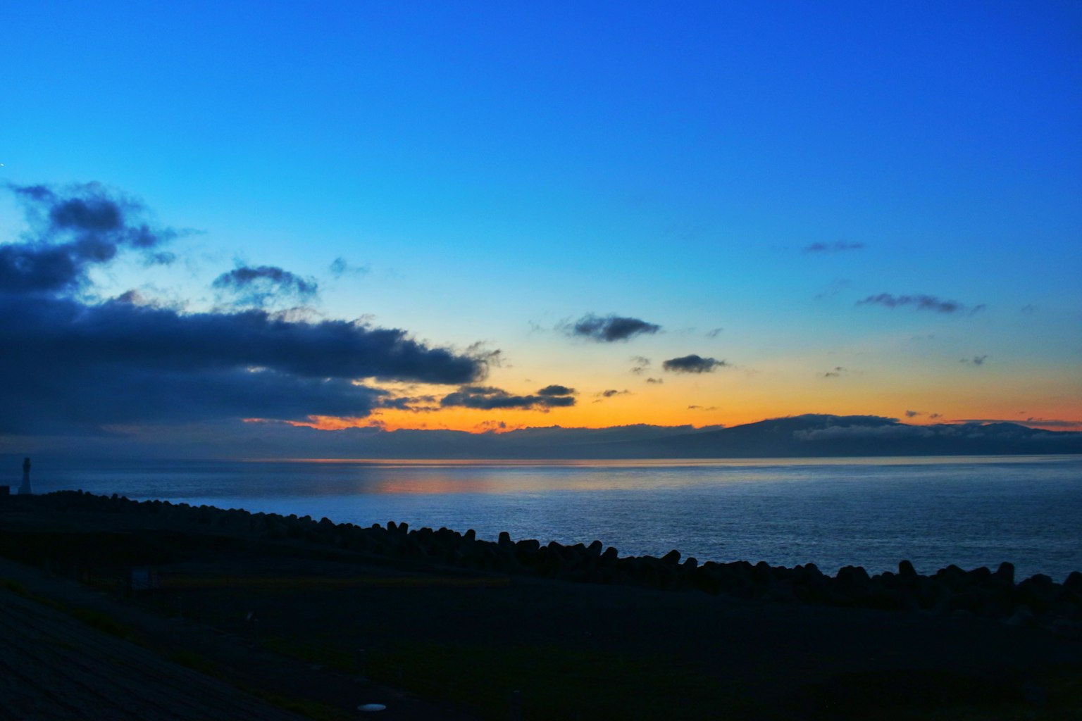 Bellissimo tramonto sul mare con cielo blu e tonalità arancioni nuvole sparse