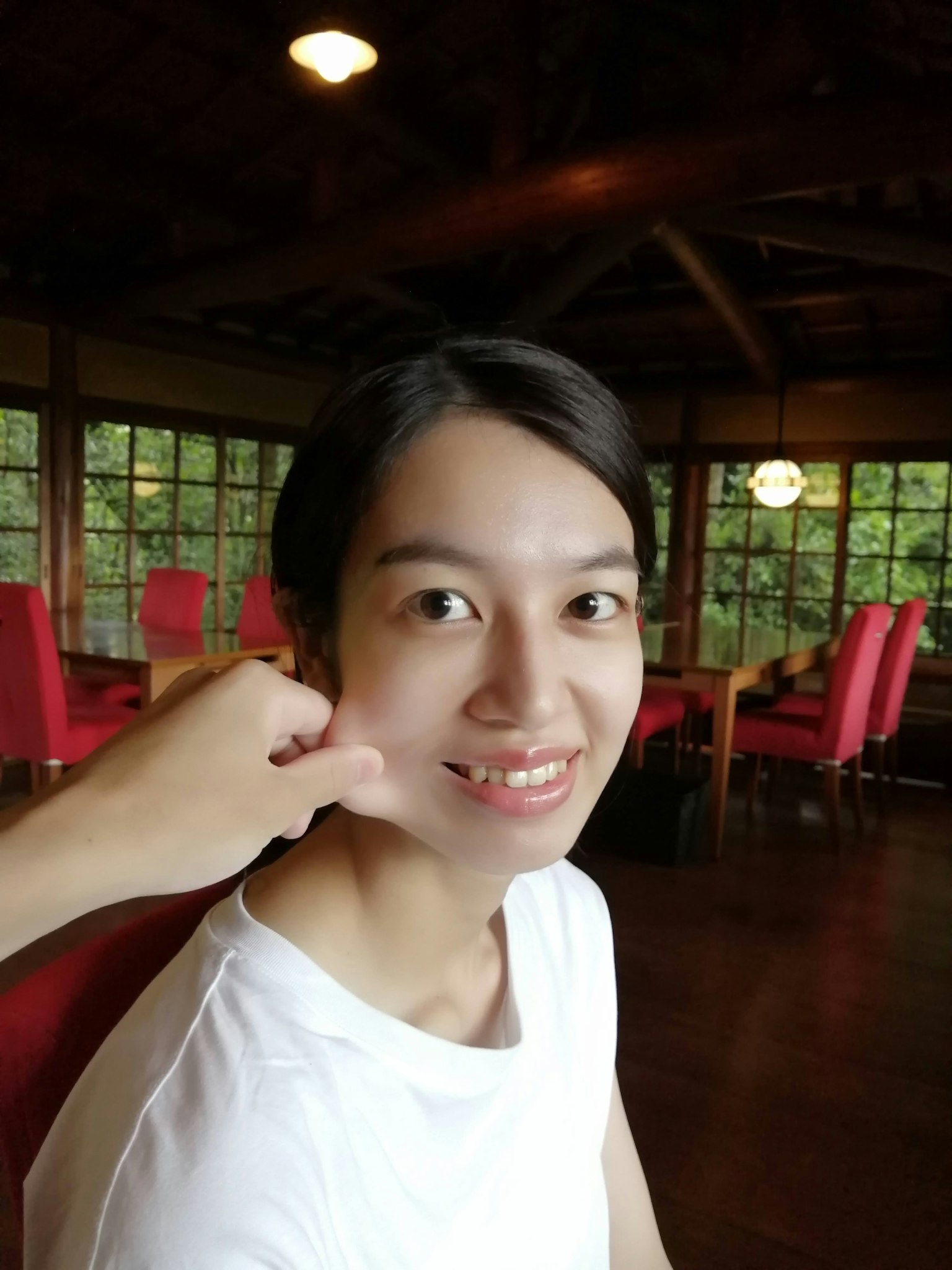 微笑的女性在红色椅子的房间里
