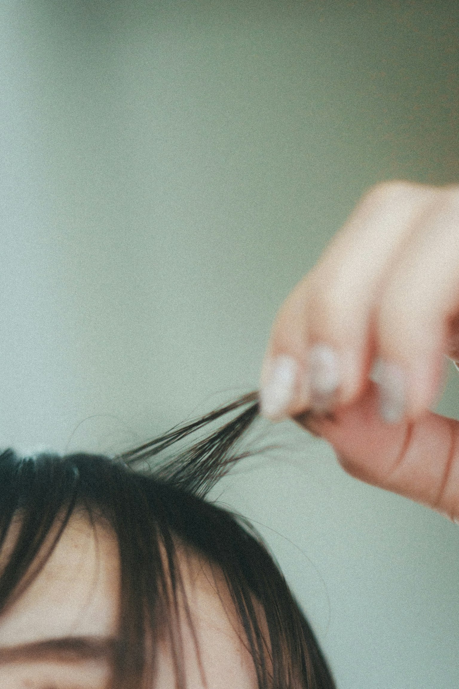 Gros plan d'une main tirant les cheveux avec un arrière-plan flou