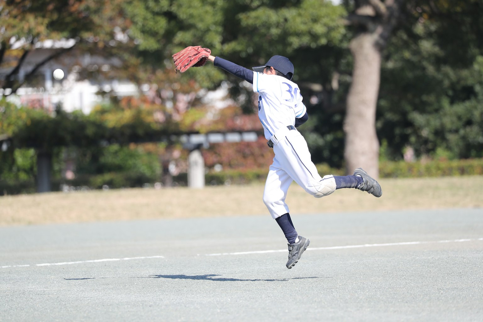 Giocatore di baseball che salta per prendere una palla