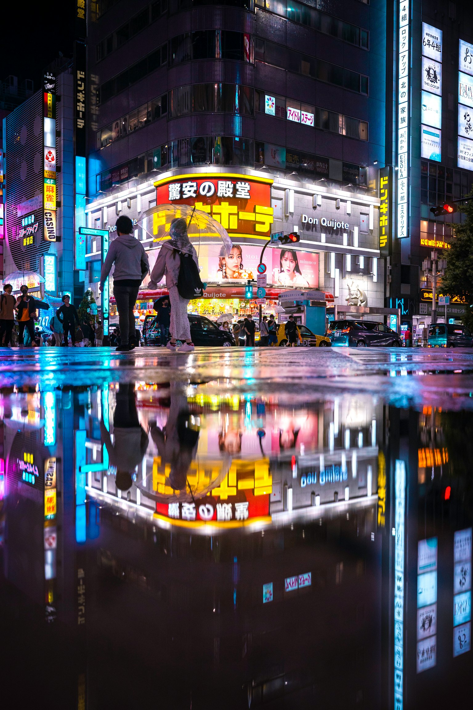 Vita notturna di Tokyo con riflesso di insegne al neon nelle pozzanghere