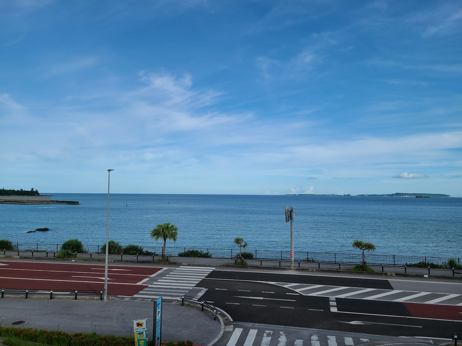 Vue panoramique de l'océan bleu et du ciel avec route et trottoir qui se croisent