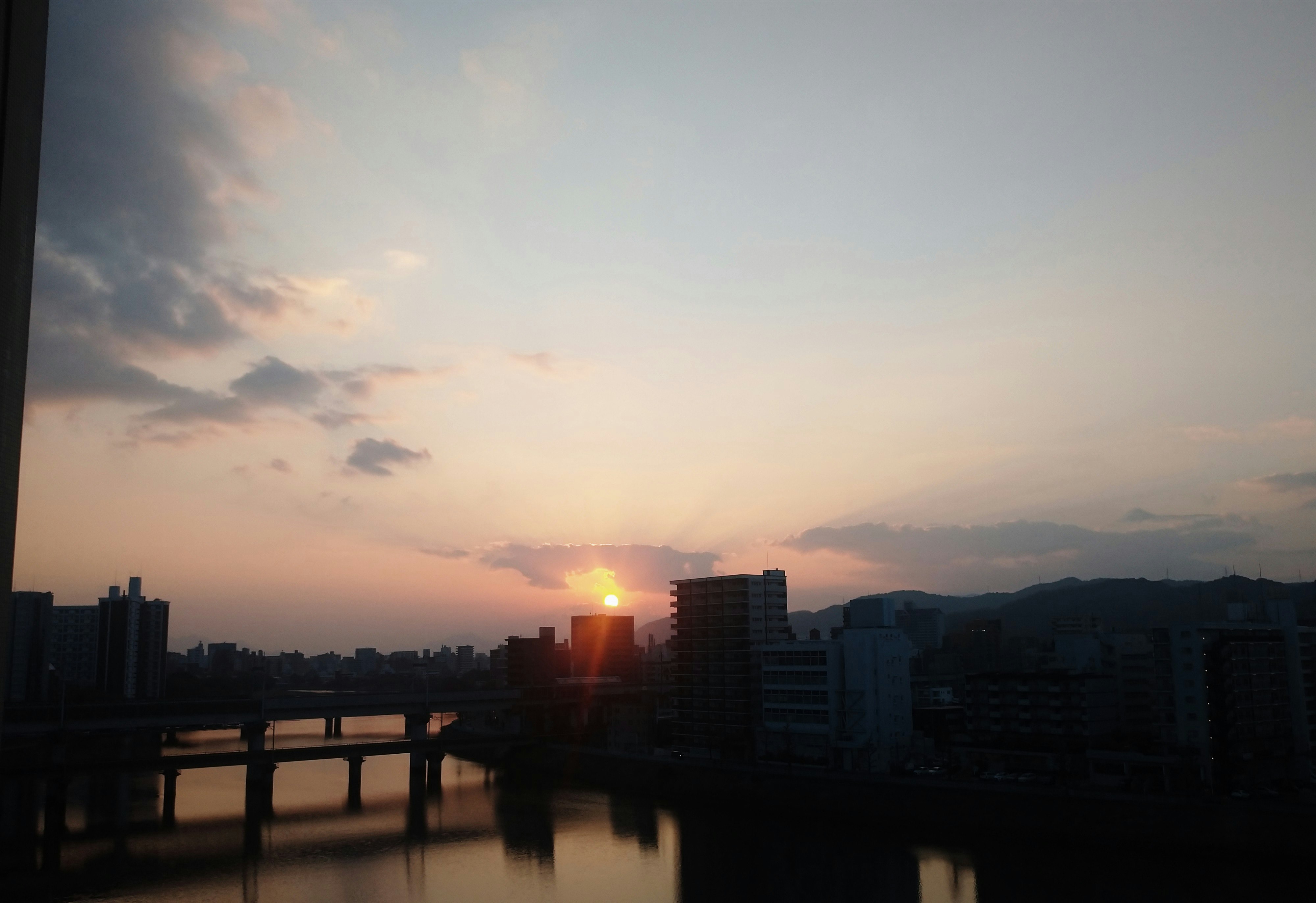 夕暮れの川沿いに沈む夕陽と空