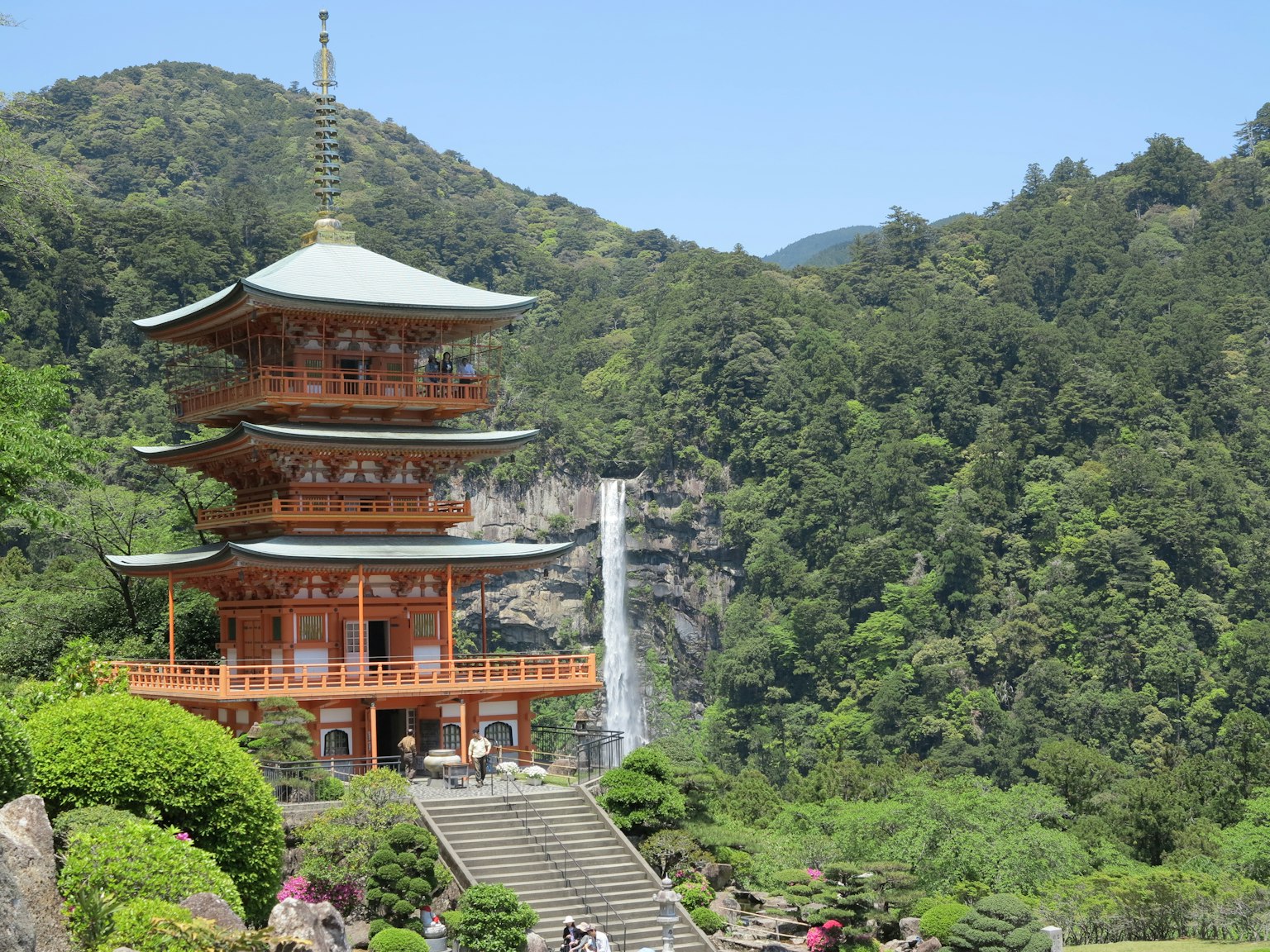 传统日本宝塔被郁郁葱葱的山脉和瀑布环绕