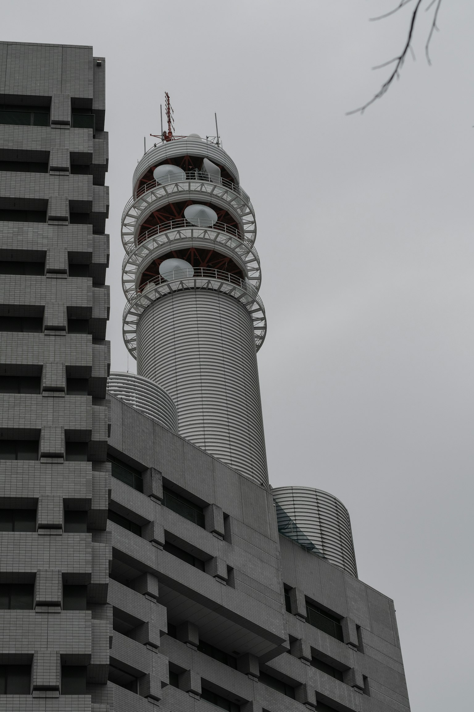 現代通信塔在灰色天空下高聳於建築之上