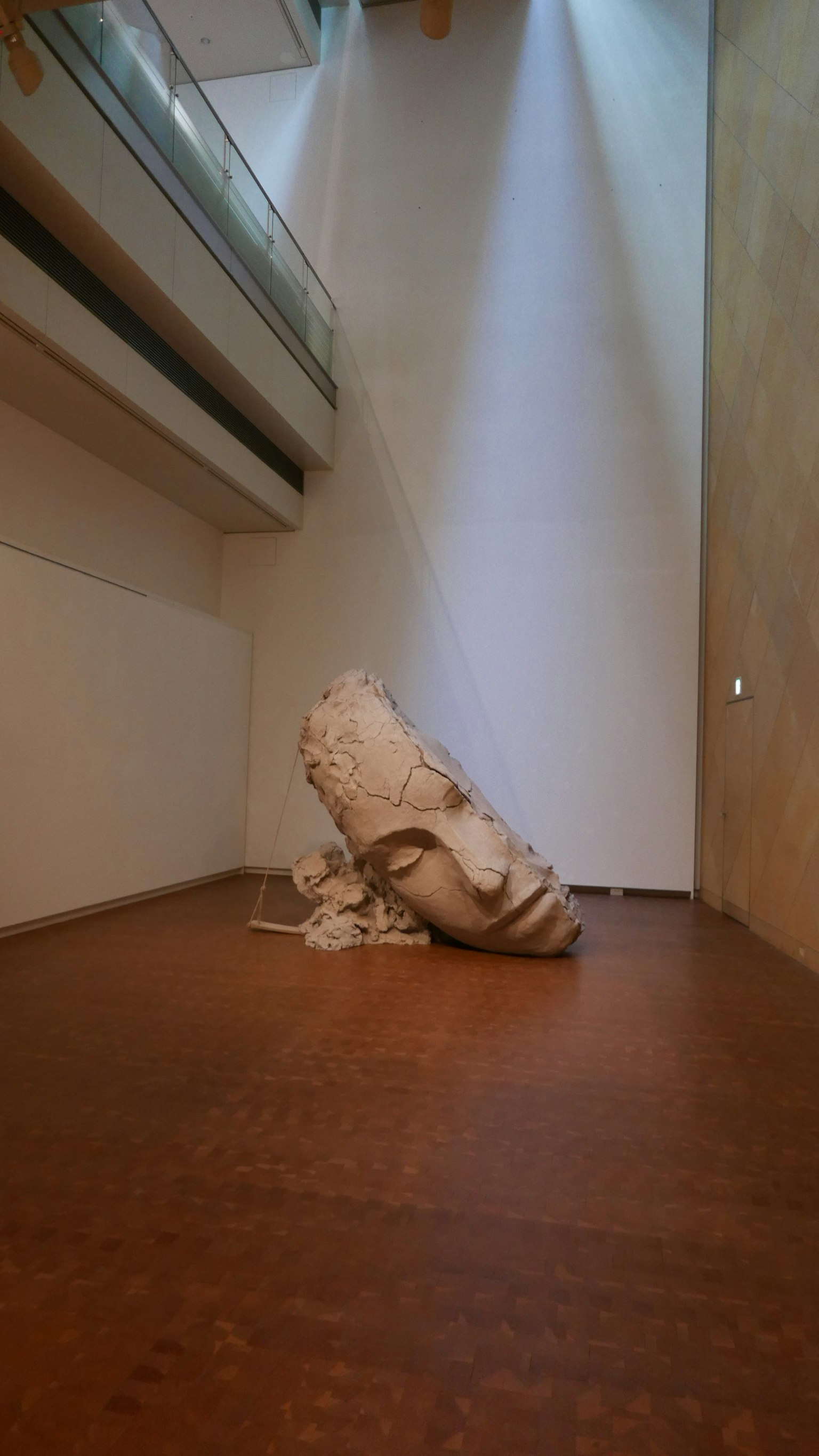 Una escultura blanca tumbada en el suelo en un espacio moderno