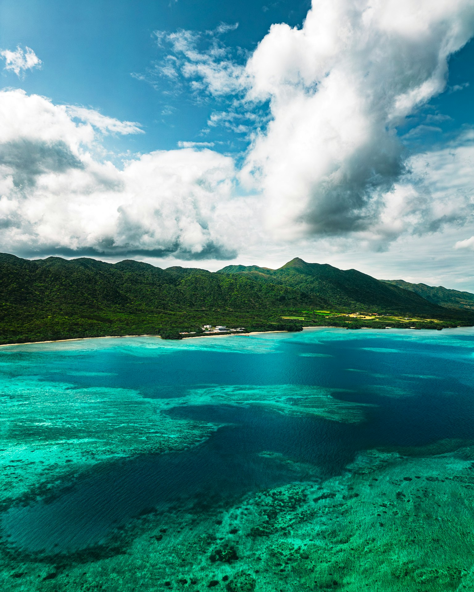Beautiful landscape with blue ocean and white clouds mountains visible in the distance