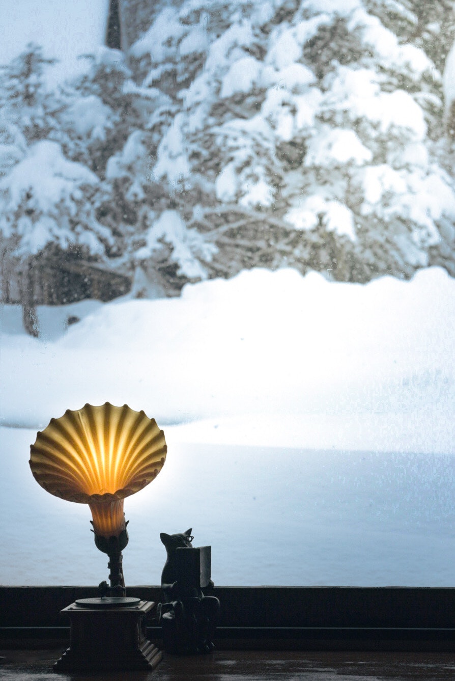 snowy outdoor bench with a seashell-shaped lamp