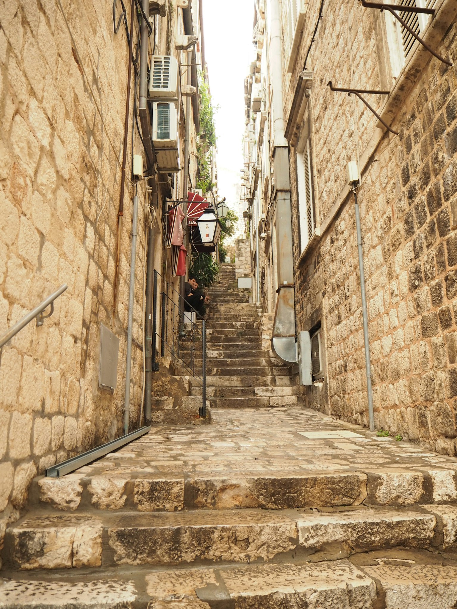Callejón estrecho de piedra con escaleras y edificios antiguos