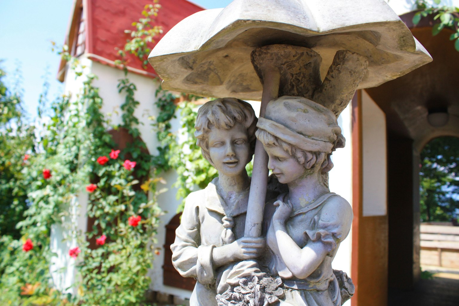 Une scène de jardin avec une sculpture d'enfants tenant un parapluie