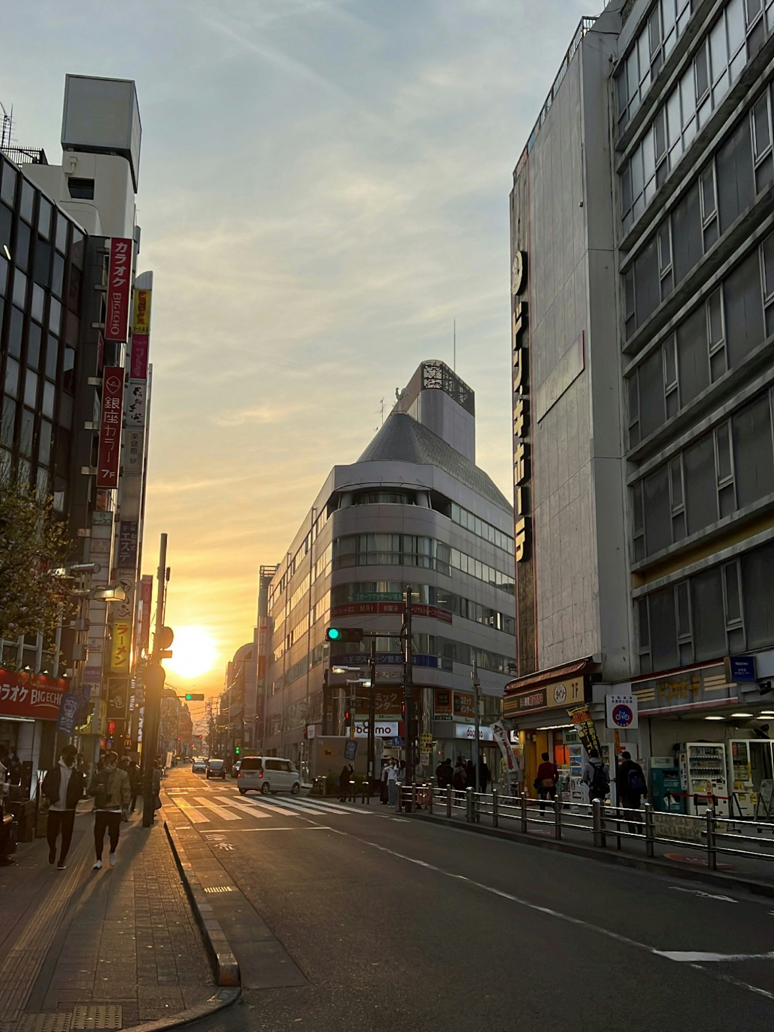 City street with buildings and sunset in the background