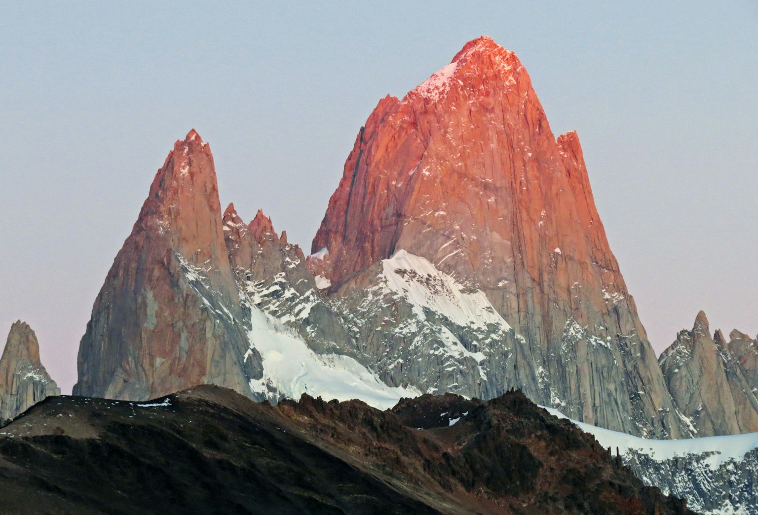 Beeindruckende Berglandschaft in Patagonien mit Gipfeln, die vom Sonnenuntergang erleuchtet werden