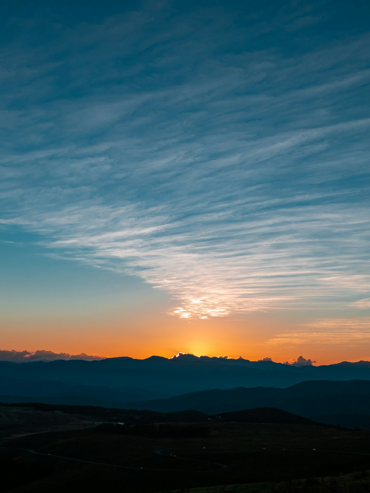 Mountain landscape with blue sky and orange sunset