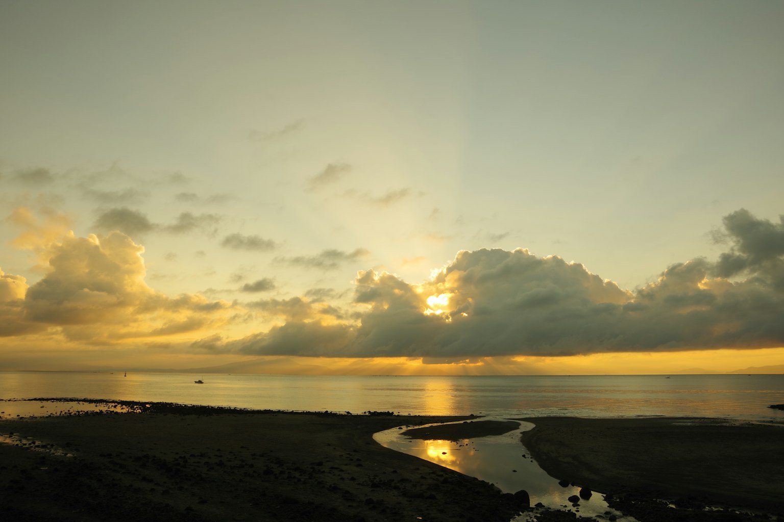 美麗的日落映照在平靜的海面上，柔和的雲朵