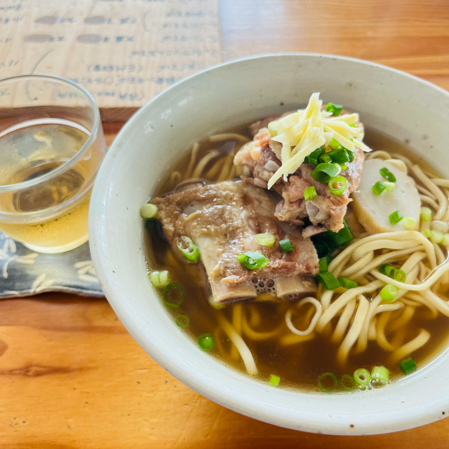 Bát ramen với hành xanh và thịt được phục vụ với đồ uống