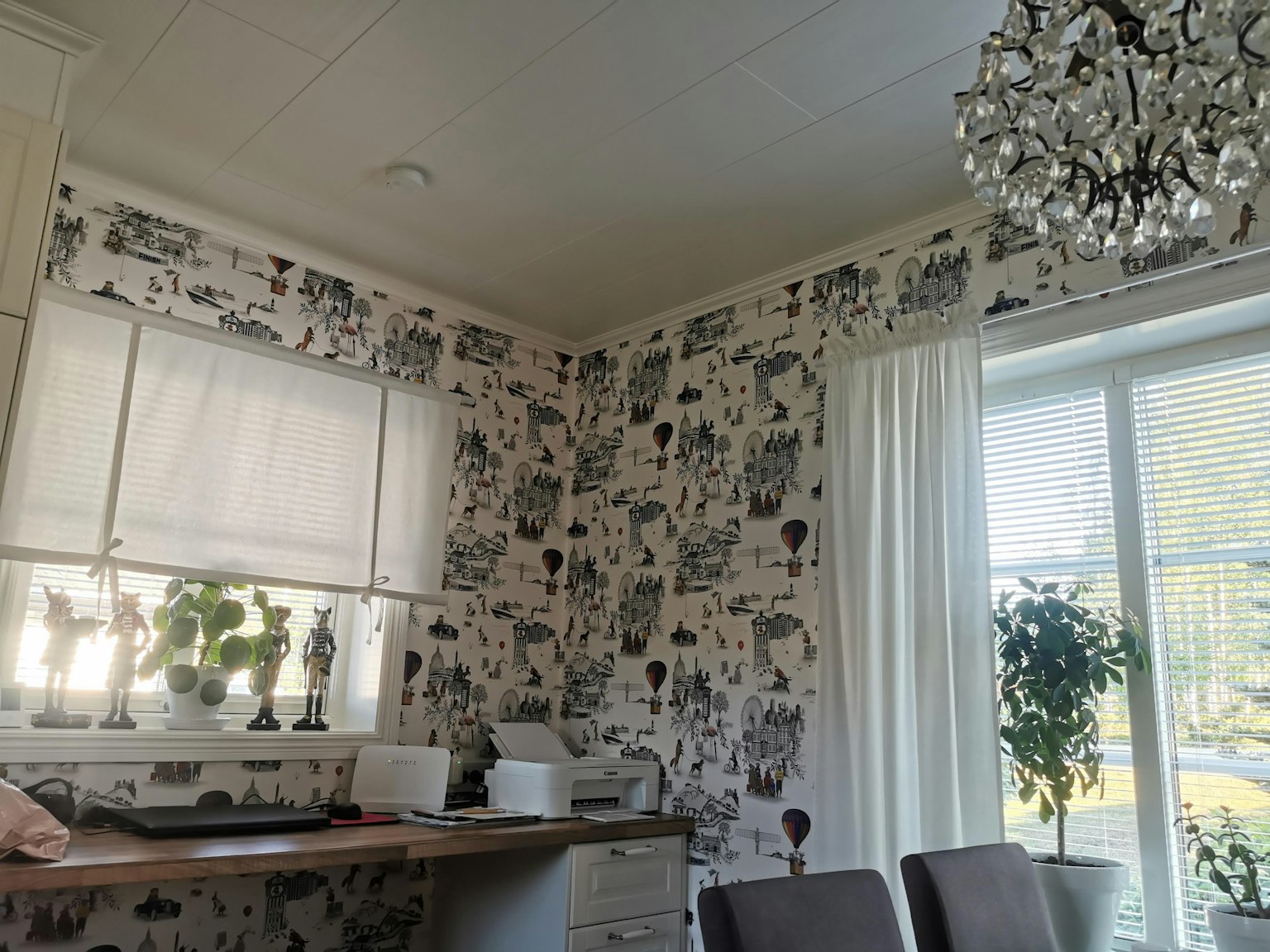 Bright dining area with monochrome patterned wallpaper and potted plants