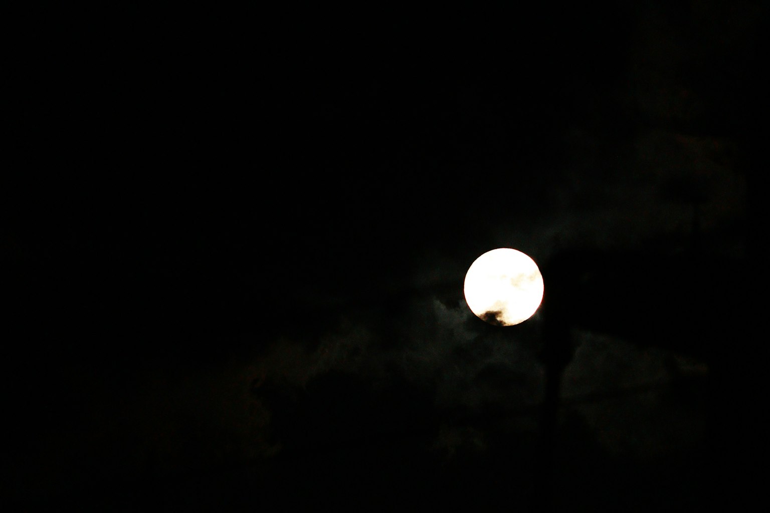 Lune brillante dans le ciel nocturne entourée de nuages sombres