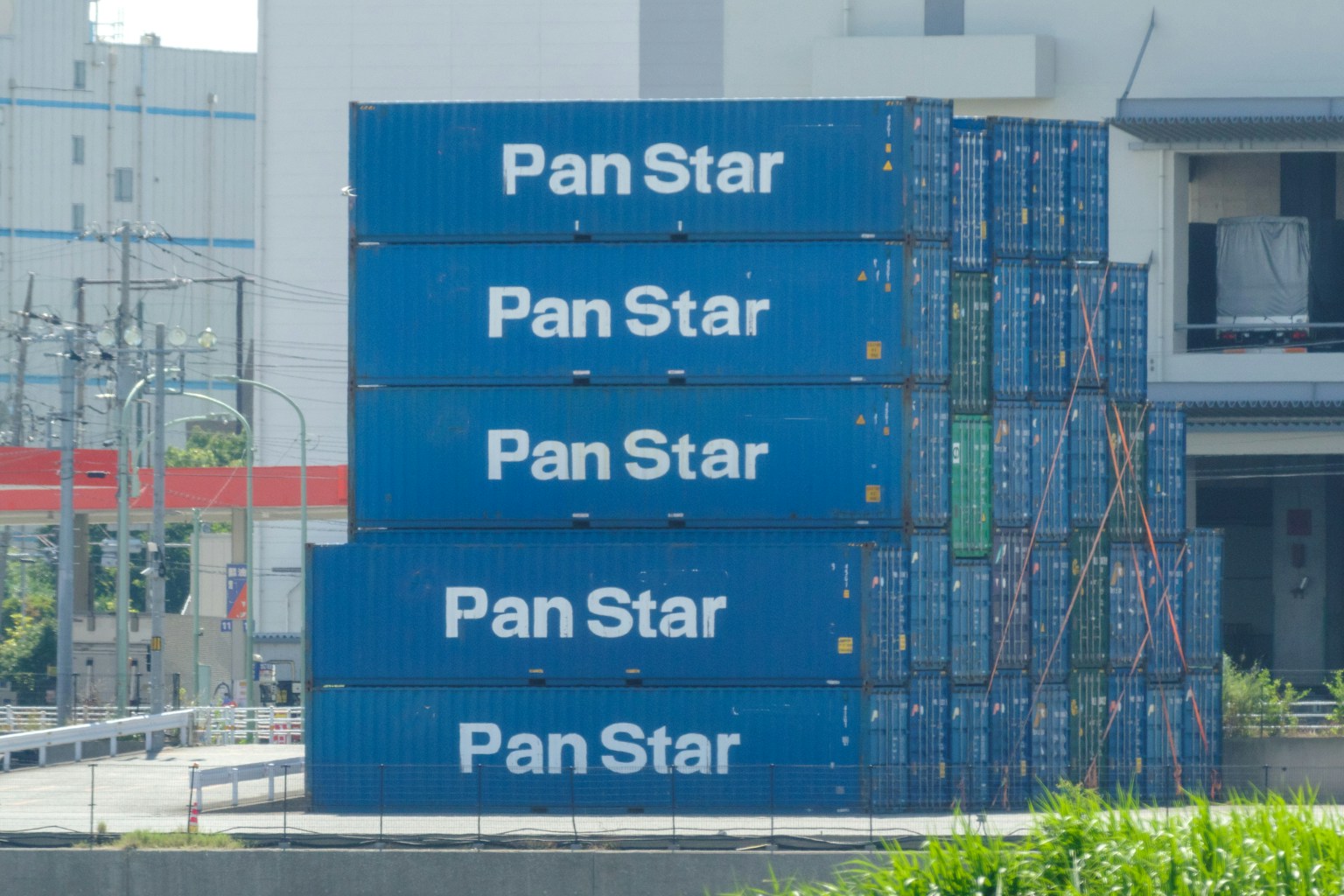 堆叠的蓝色集装箱上重复显示Pan Star标志