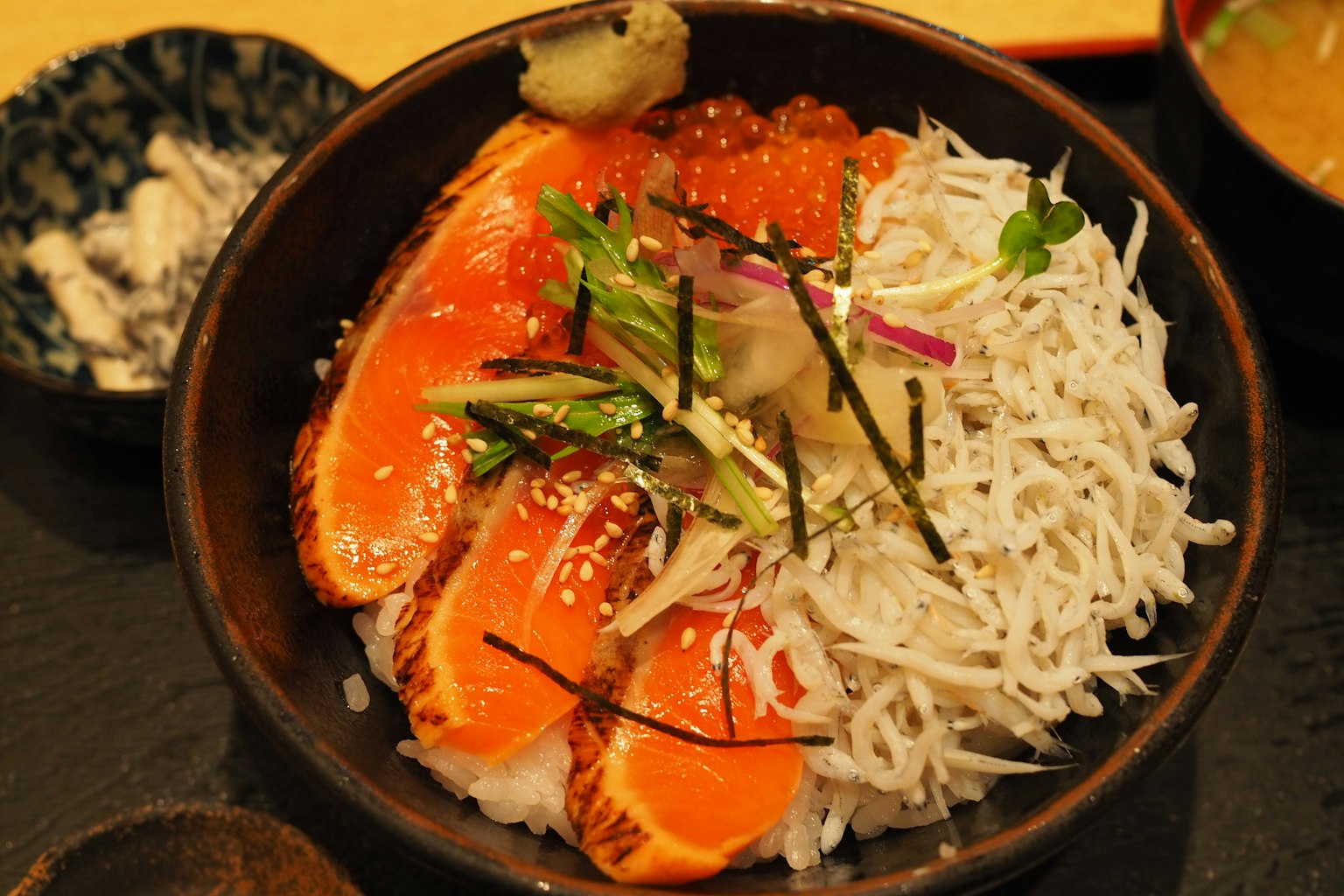 Reisschüssel mit Lachs und Shirasu mit bunten Toppings