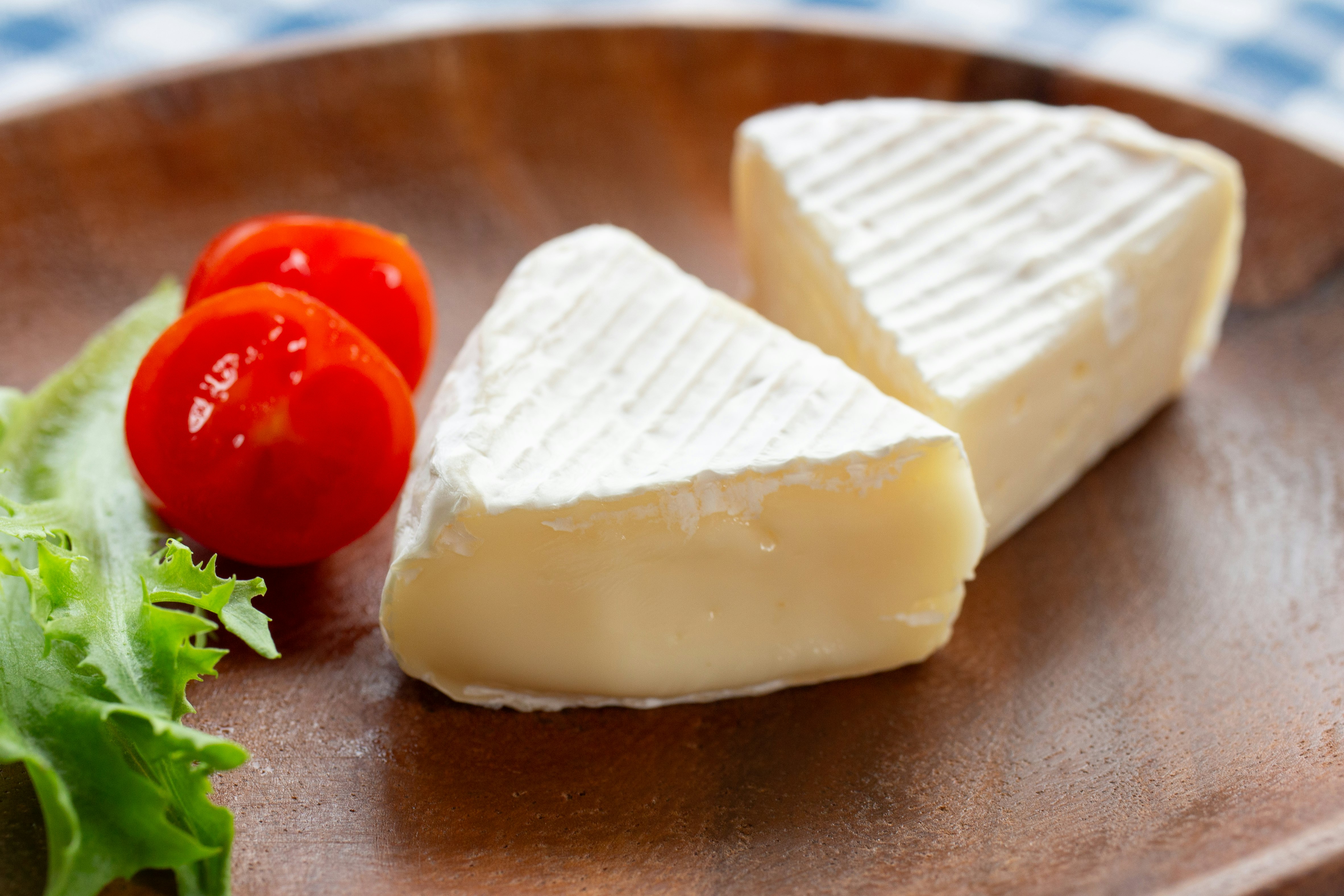 Gajos de queso y tomates cherry sobre una tabla de madera