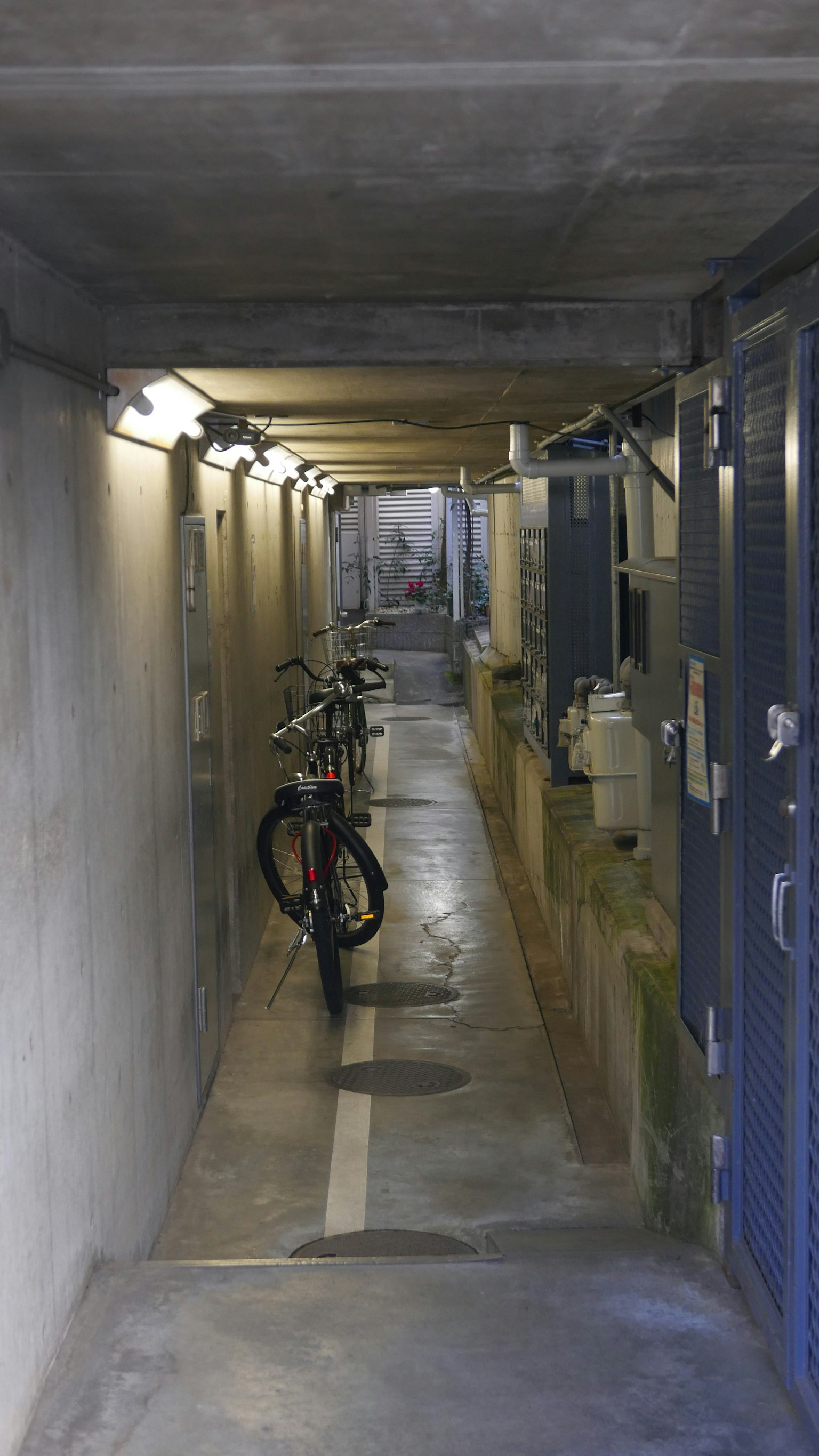 Narrow corridor with parked bicycles and blue lockers