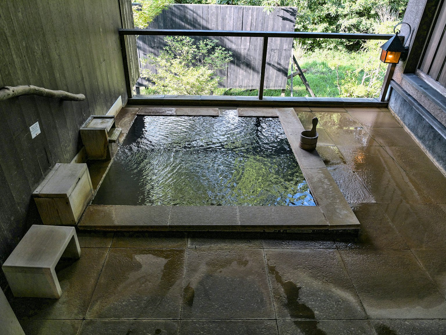 浴室内有自然光的小型温泉浴缸和木制长椅