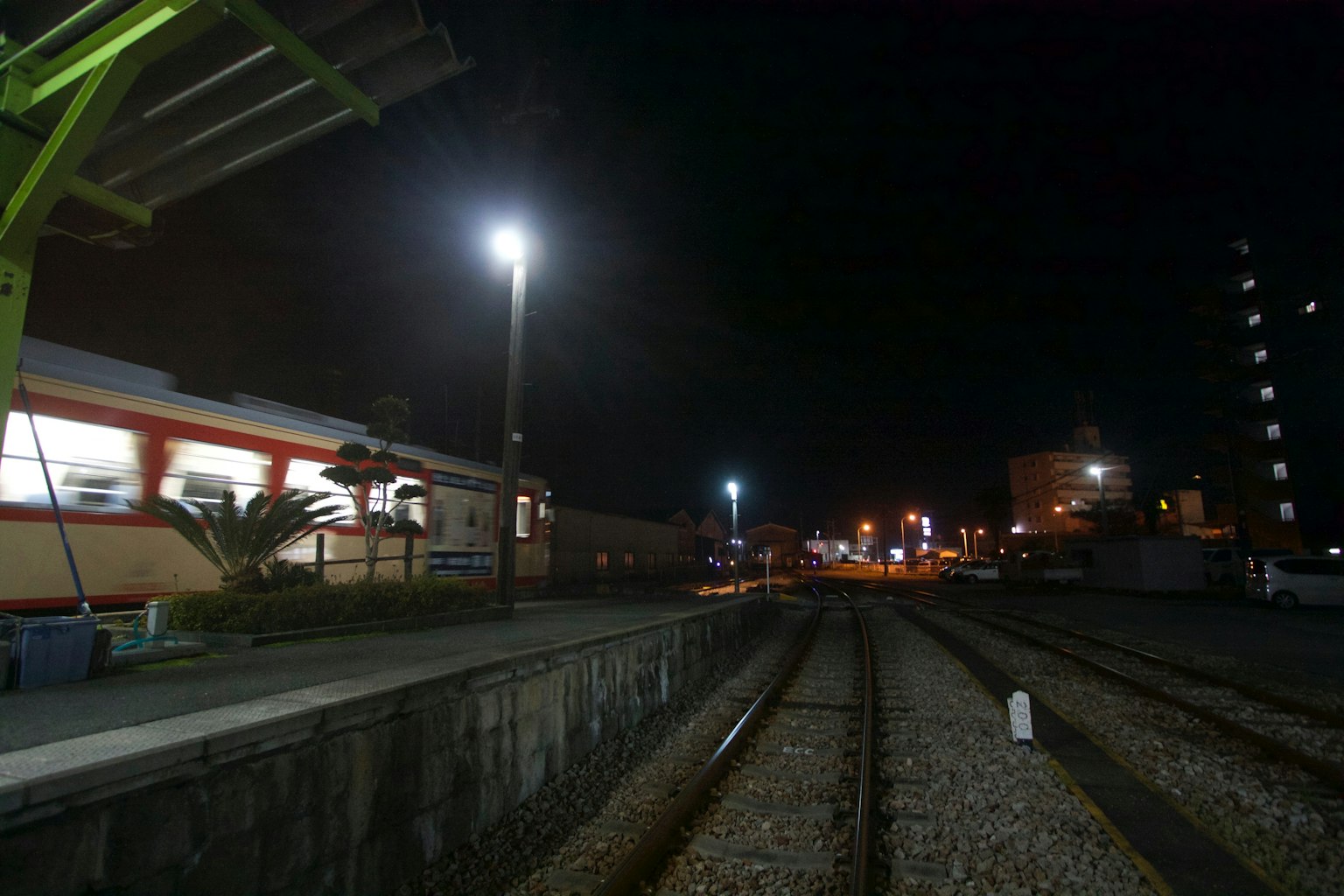 Vista notturna di una stazione ferroviaria con banchine illuminate