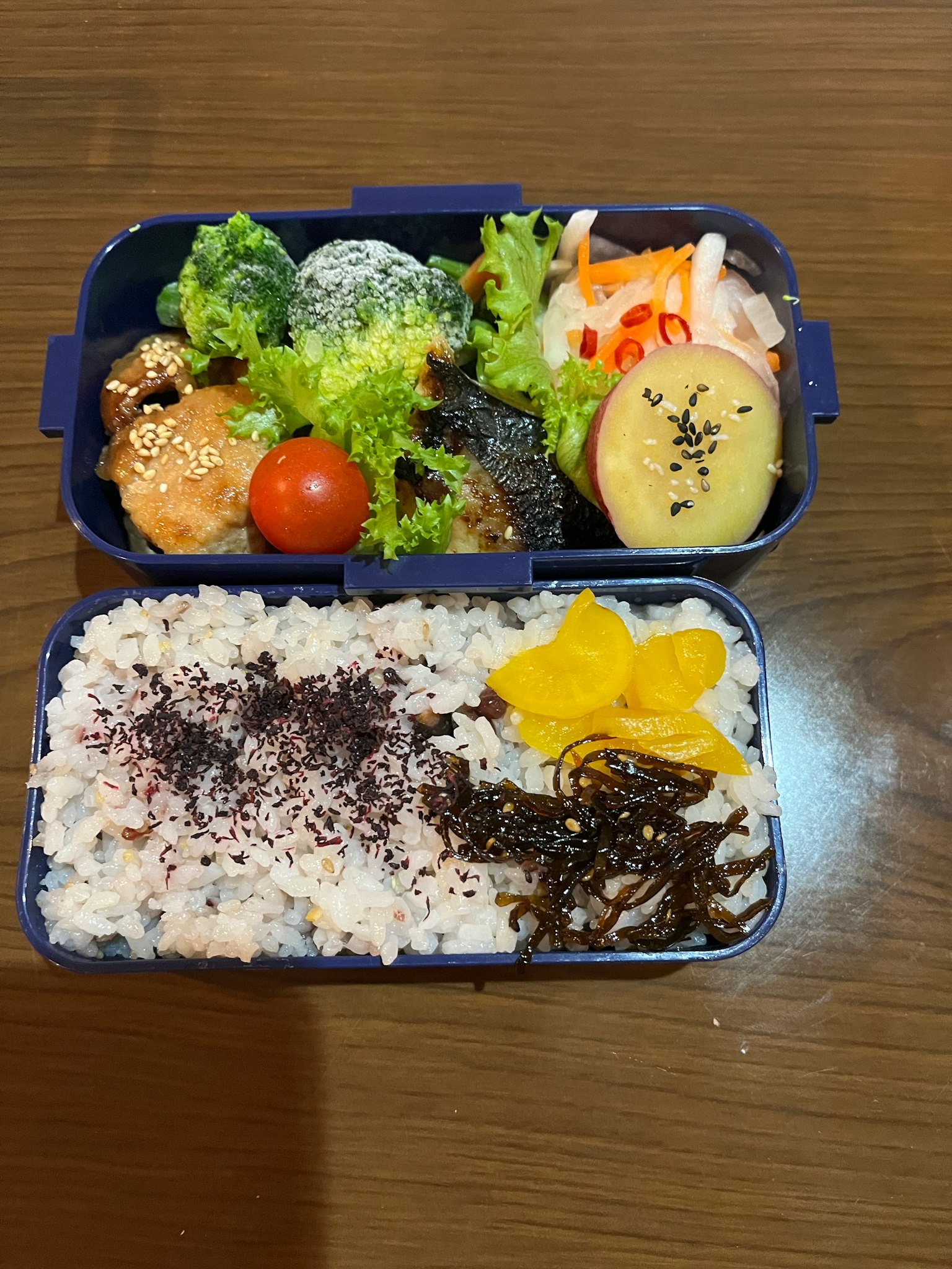 一個裝滿色彩繽紛菜餚和米飯的便當盒