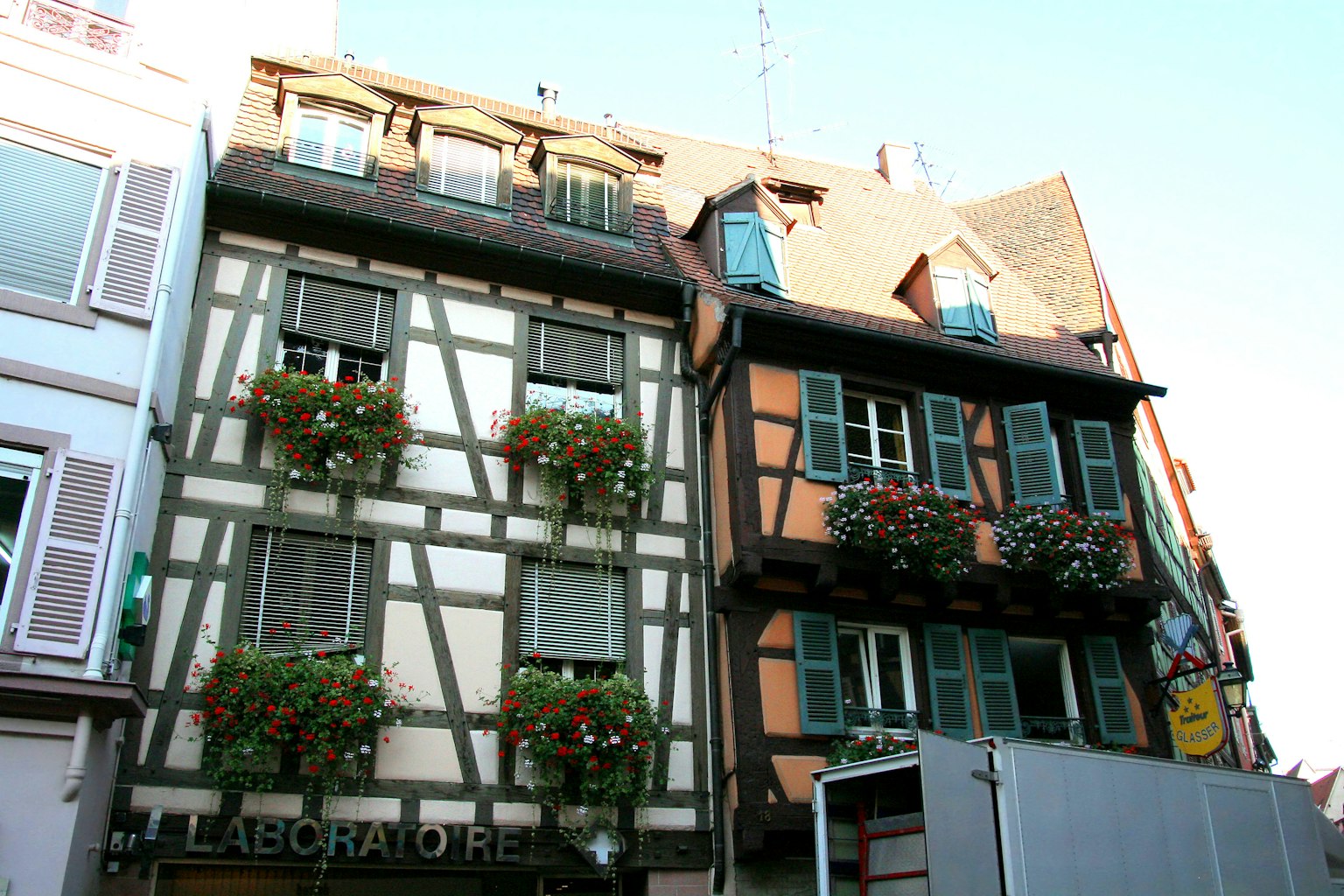 Façade de maisons à colombages traditionnelles à Strasbourg avec des balcons ornés de fleurs