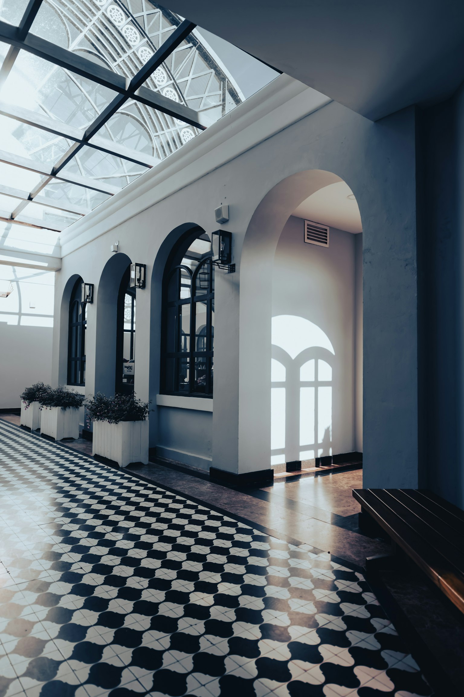 Lorong modern yang terang dengan lantai bergaris dan jendela melengkung