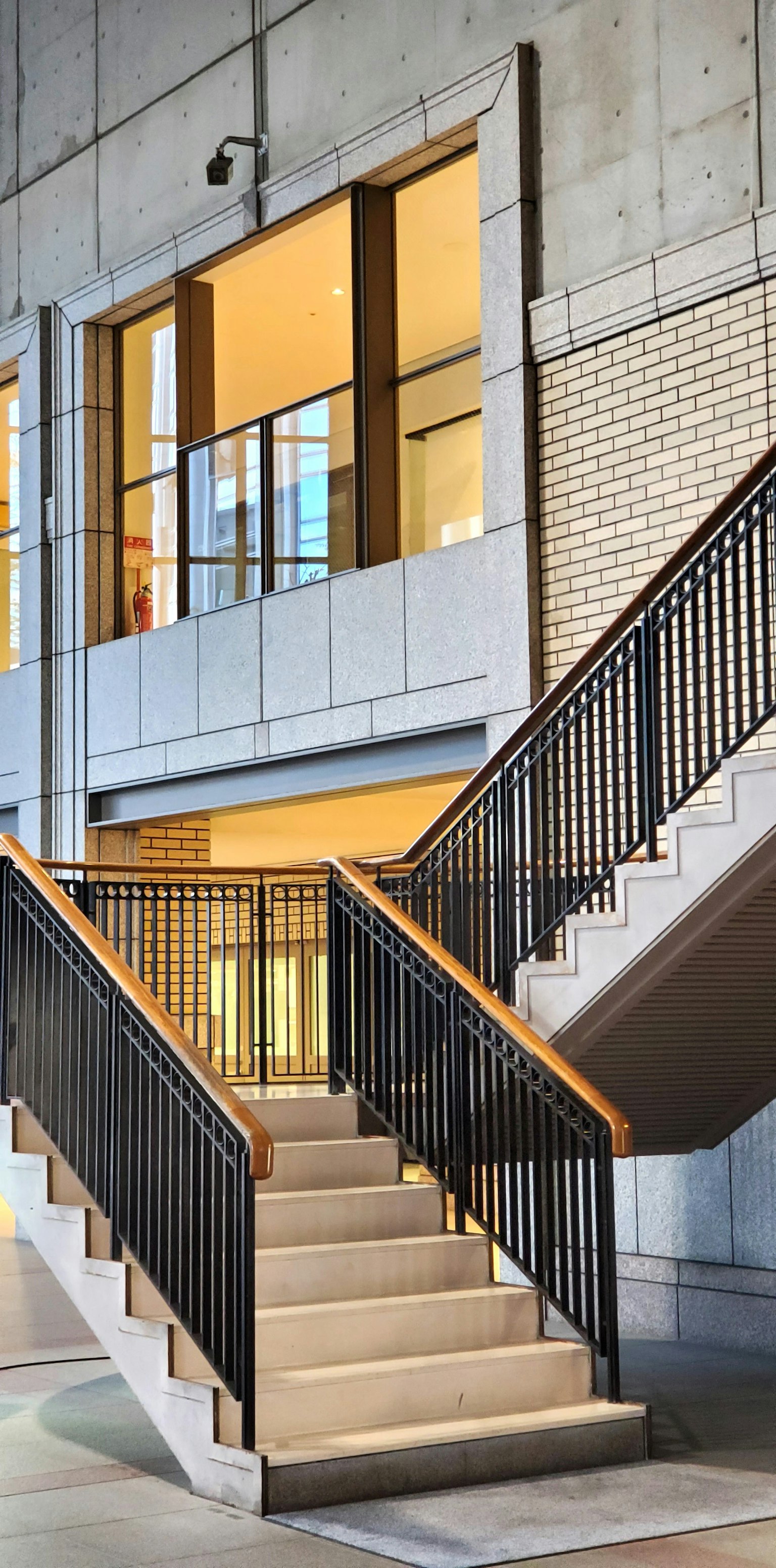 Immagine interna di un edificio moderno con una scala pareti in cemento e corrimano in metallo con luce naturale che entra da grandi finestre