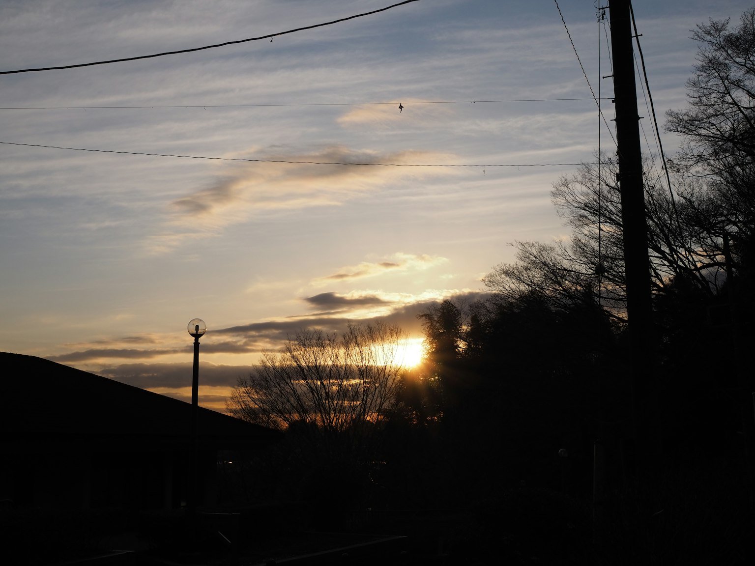 Silhouette von Strommasten vor einem Sonnenuntergangshimmel