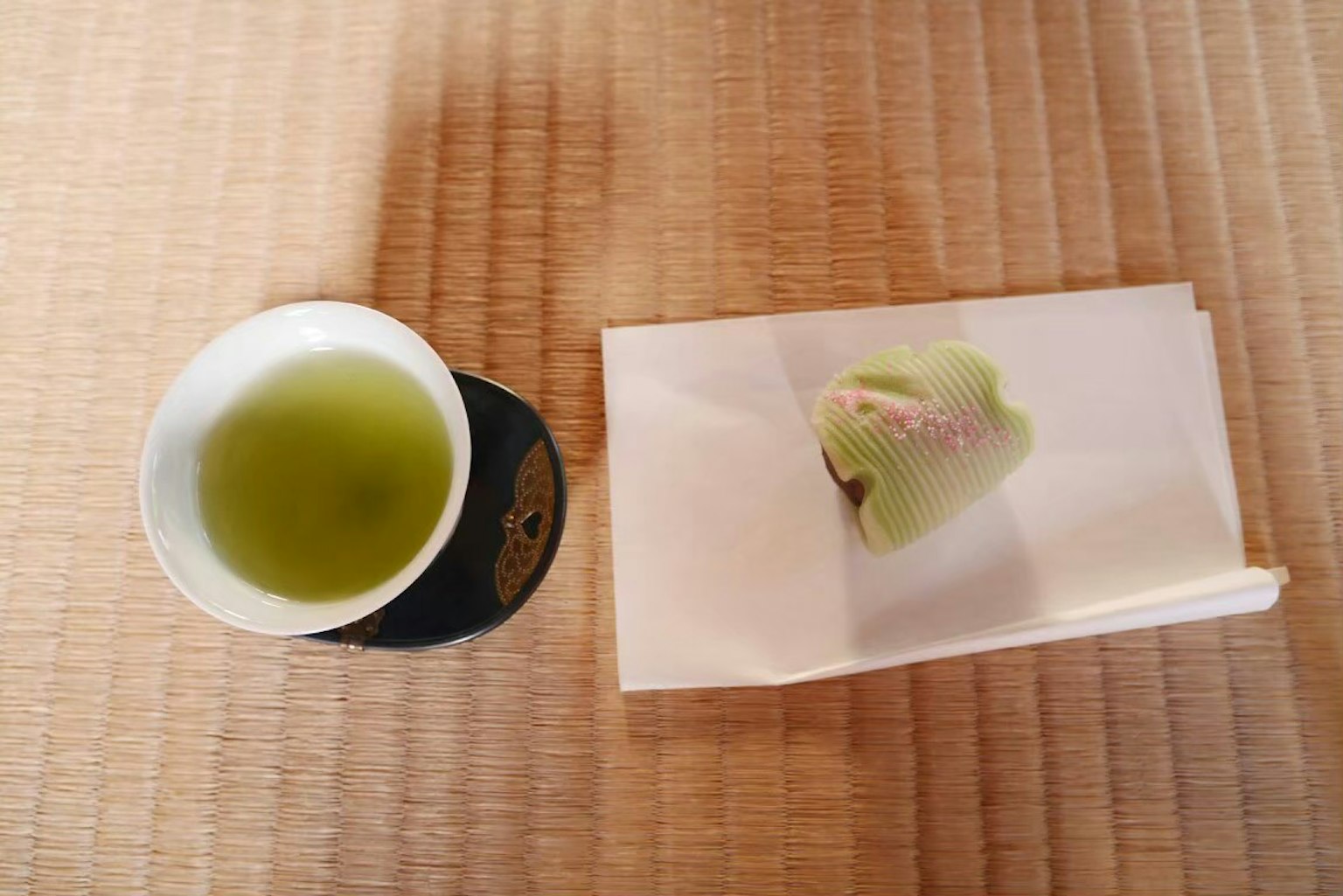 Teh hijau dan kue Jepang di meja tatami