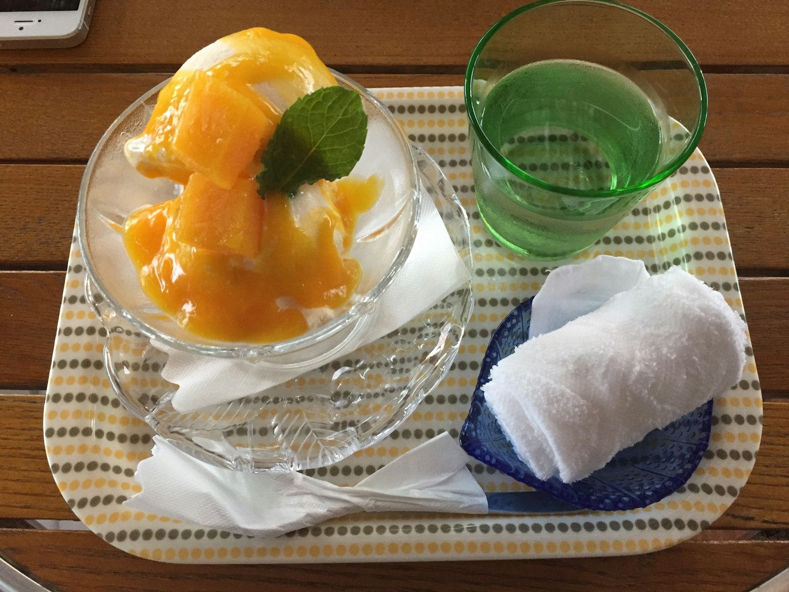 Dessert con gelato al mango in una ciotola trasparente guarnito con foglie di menta