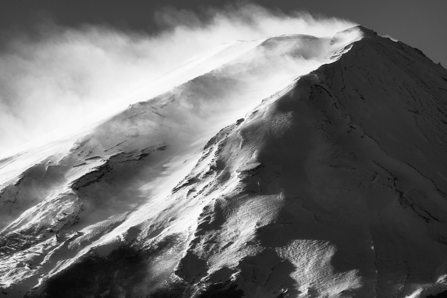 Vent et neige tourbillonnant au sommet de la montagne