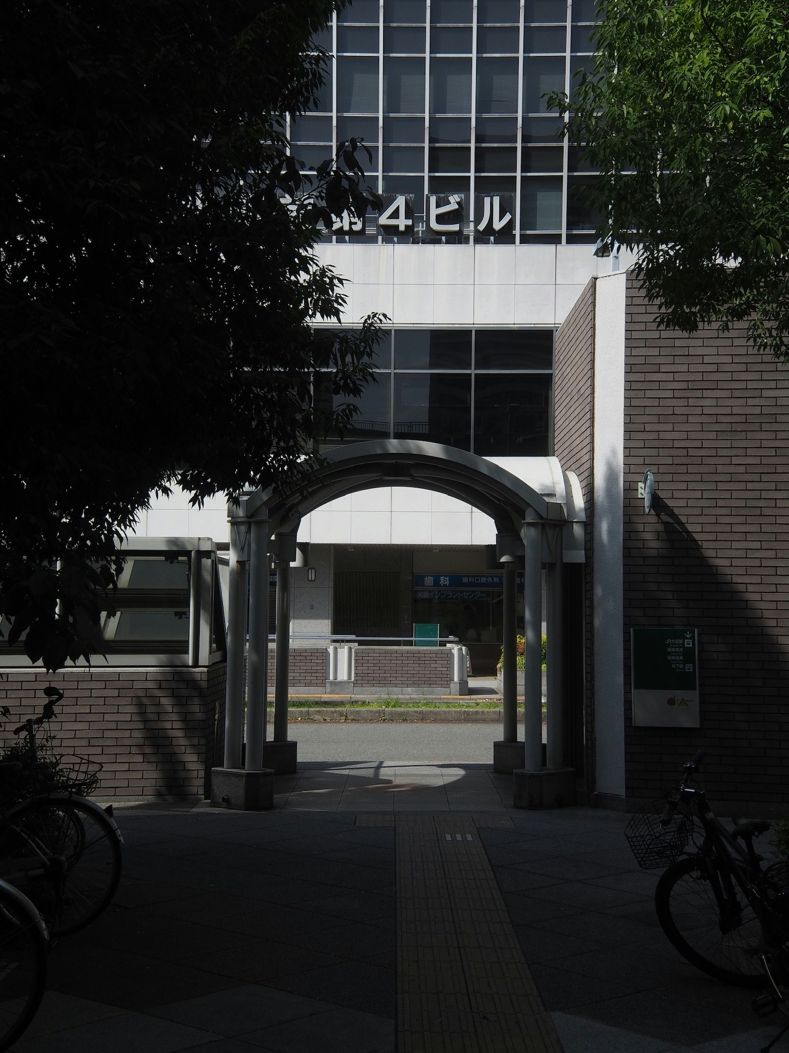 建物の入り口にあるアーチと自転車が並ぶ風景