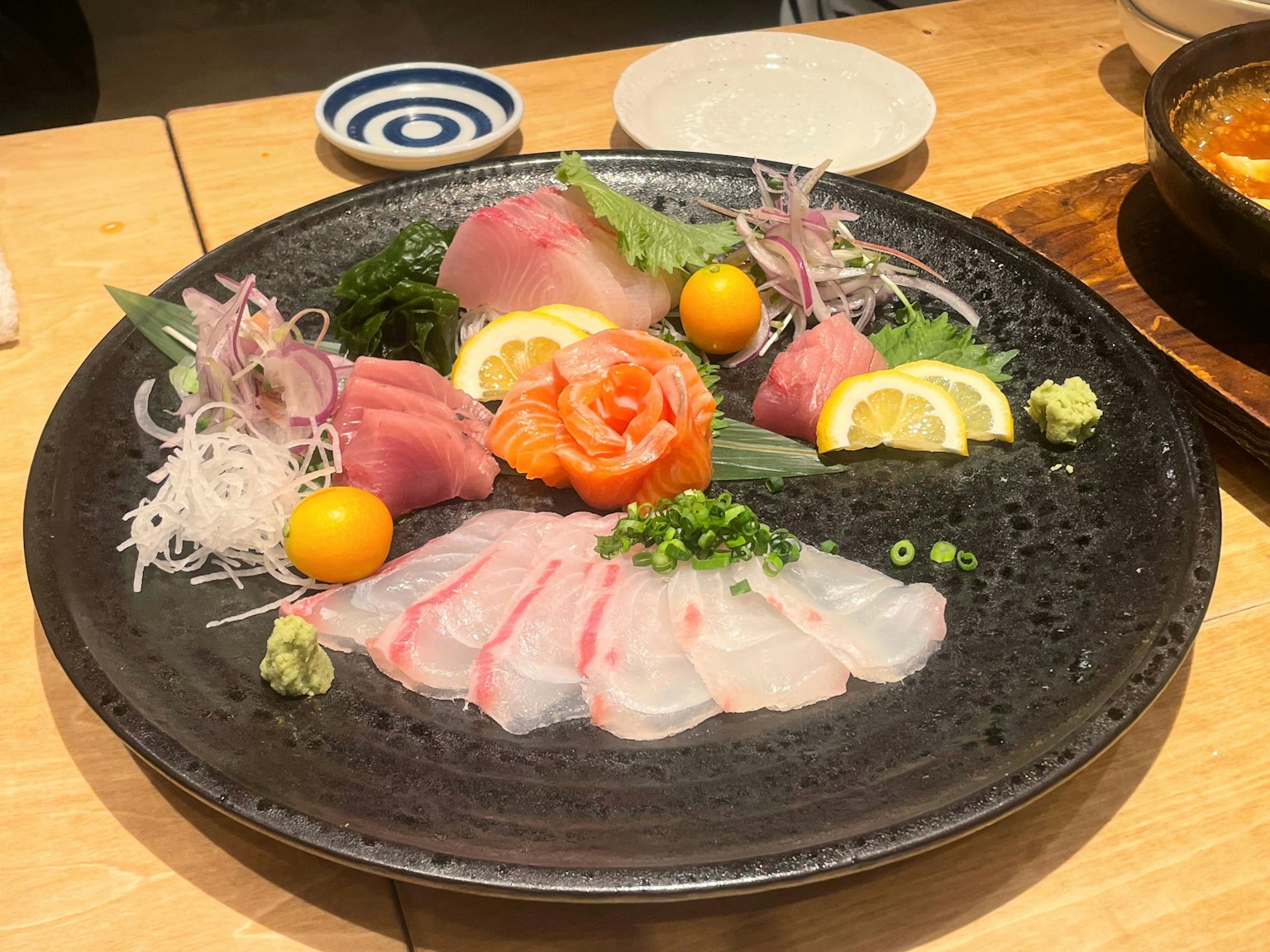 Piring sashimi yang disusun dengan indah dengan irisan ikan segar dan hiasan