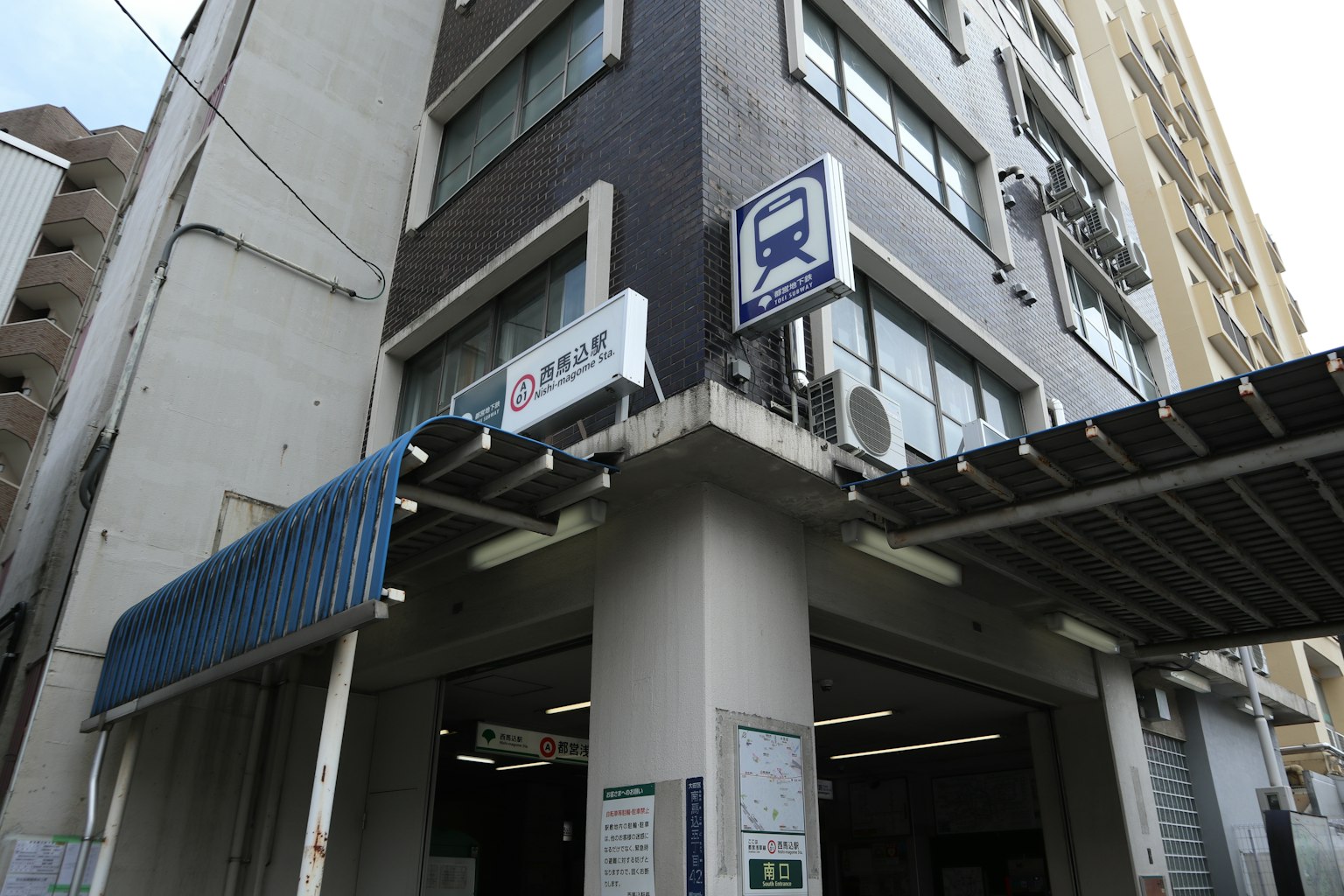 黑色外牆和藍色遮陽篷的火車站入口