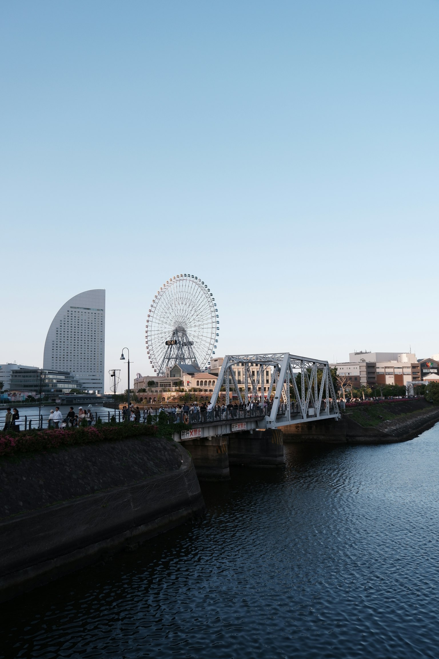 Horizonte de Yokohama con un puente y una noria bajo un cielo azul claro