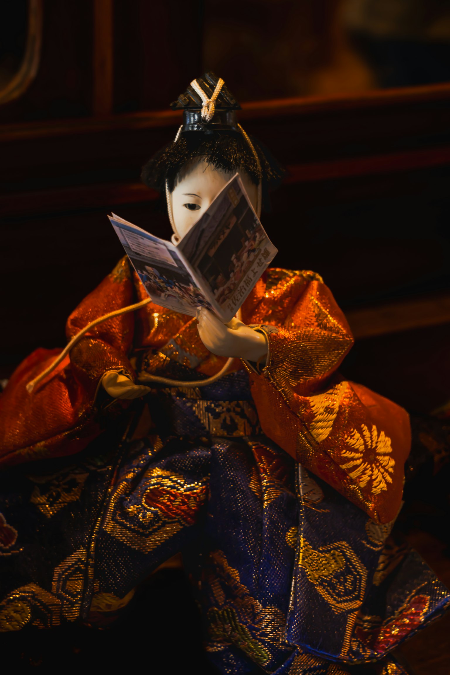Una bella bambola in kimono che legge un libro