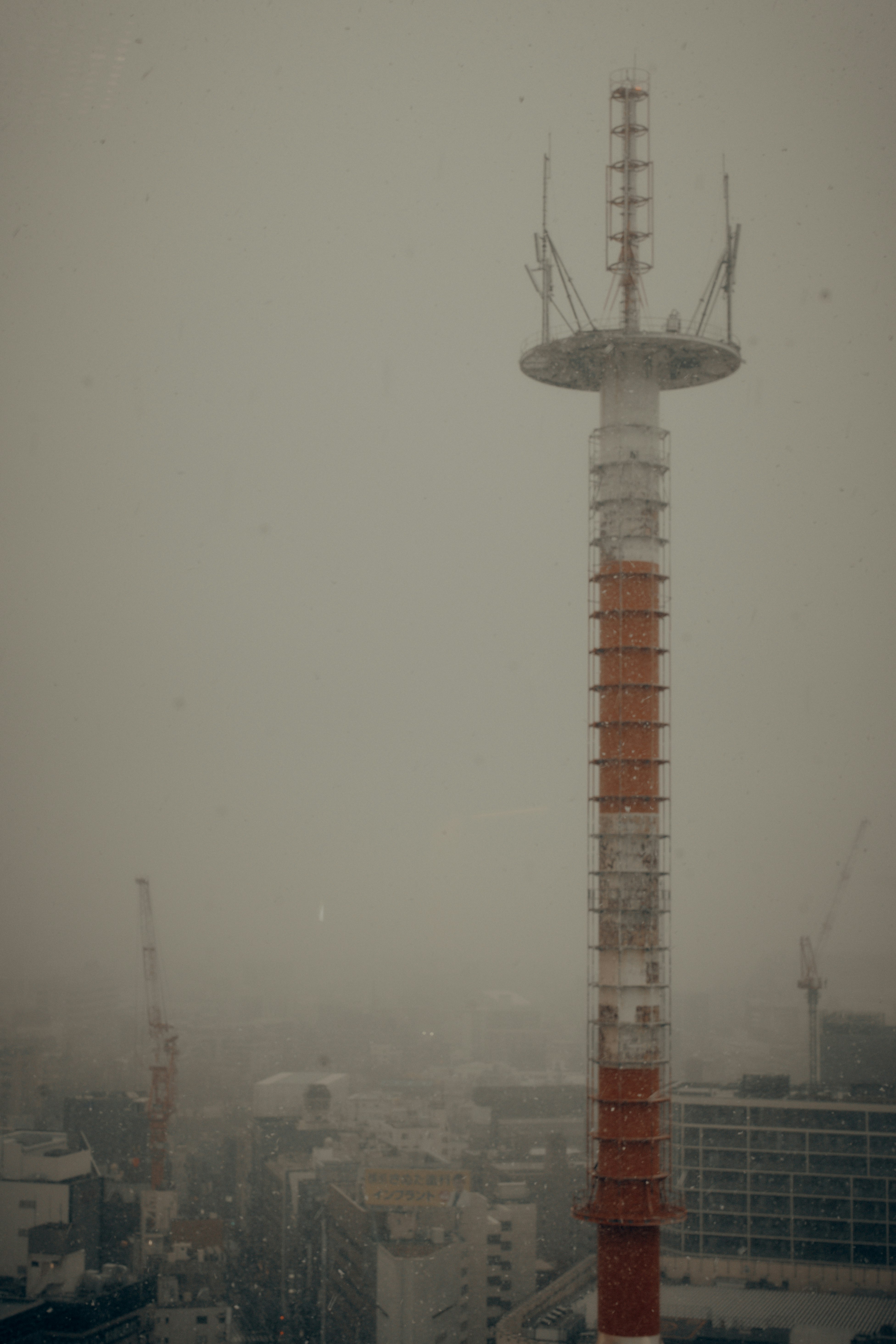 tall industrial smokestack rising through fog